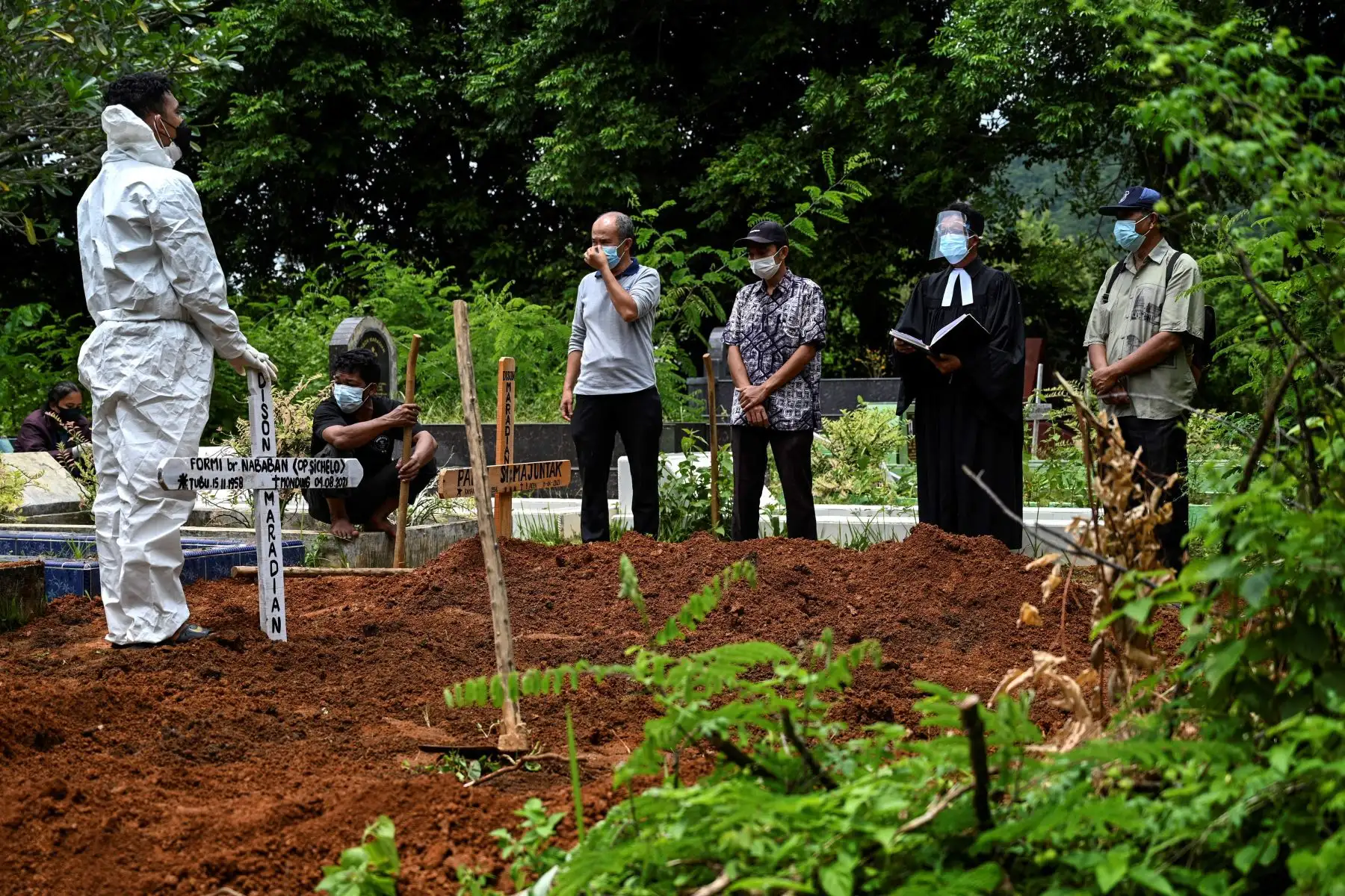 Familiares rezan después de bajar el ataúd de una víctima del coronavirus en un cementerio en Darul Imarah, en las afueras de Banda Aceh.
Foto: AFP