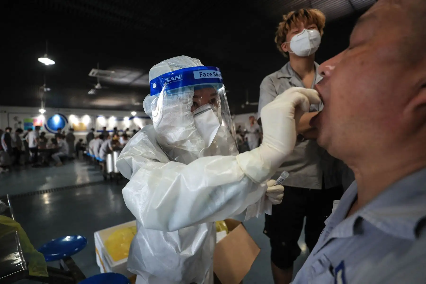Un trabajador recibe una prueba de ácido nucleico para el coronavirus  en el comedor de una fábrica de piezas de automóviles en Wuhan, en la provincia central de Hubei, China.
Foto: AFP