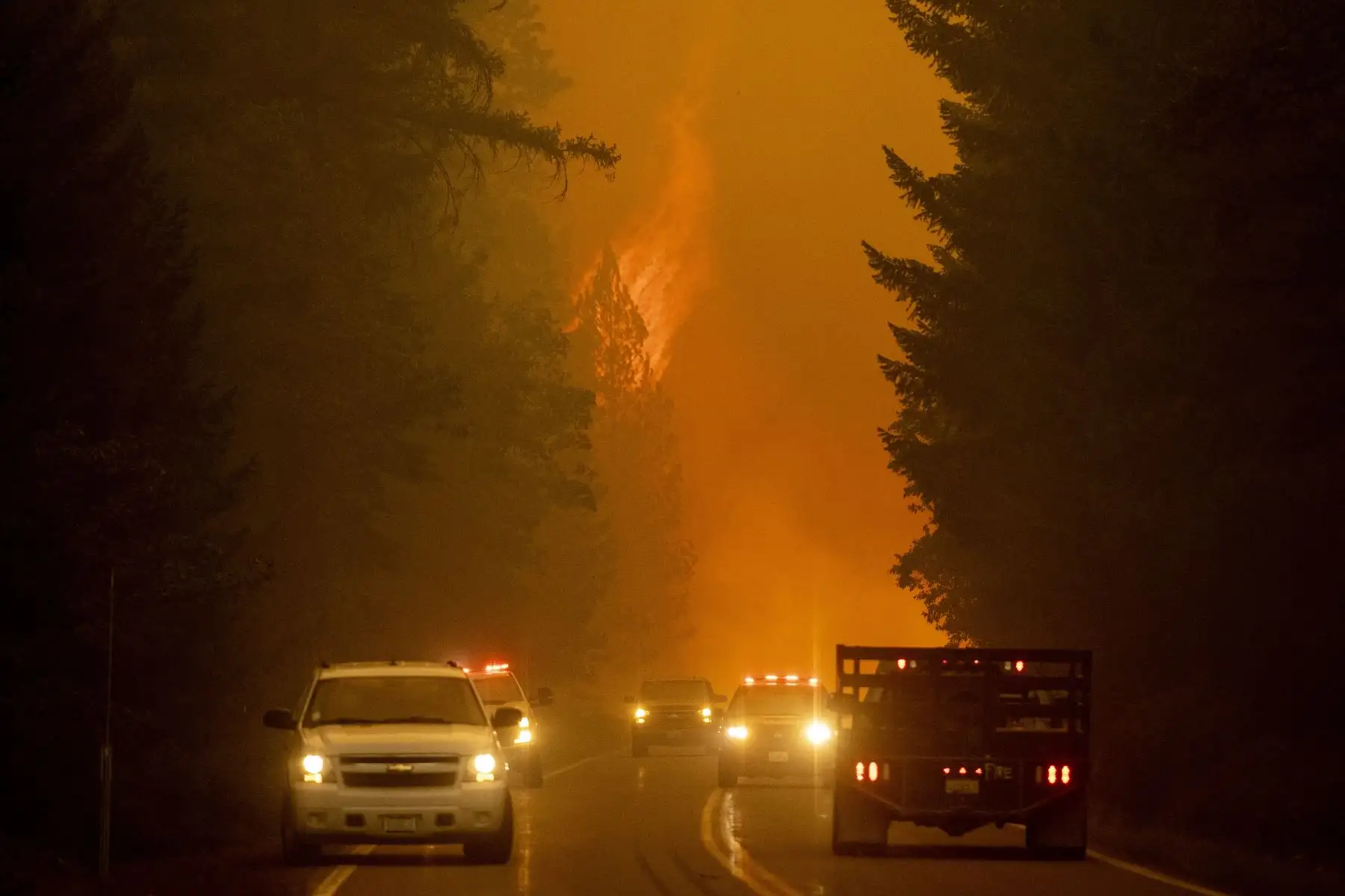 Los bomberos monitorean la escena mientras las llamas del incendio de Dixie saltan a través de la autopista 89 cerca de Greenville, California. Foto: AFP