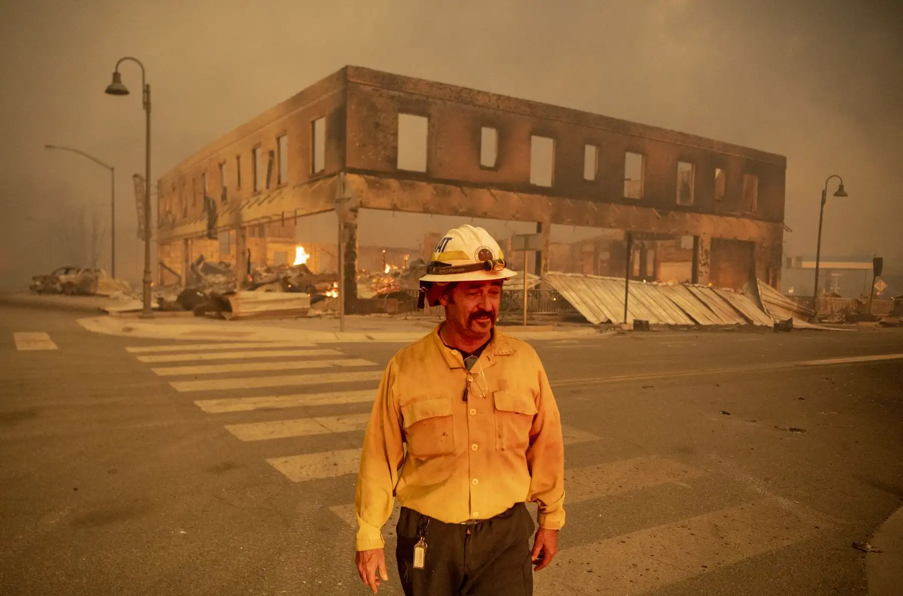 El jefe del batallón Sergio Mora observa mientras el incendio de Dixie arde en el centro de Greenville, California. El incendio de Dixie arrasó decenas de hogares y negocios en el centro de Greenville. Foto: AFP