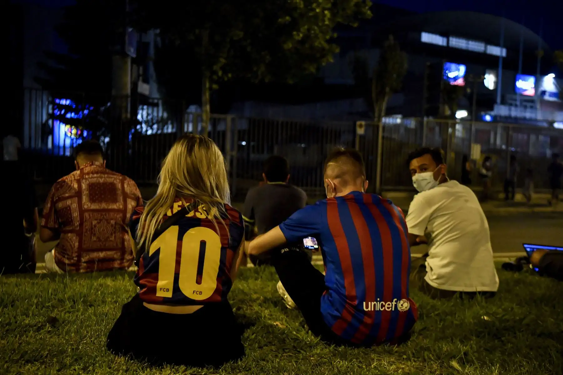 Una pareja con camisetas del delantero argentino del Barcelona Lionel Messi se sienta en el césped mientras los aficionados se reúnen frente al estadio Camp Nou en Barcelona .
Foto: AFP