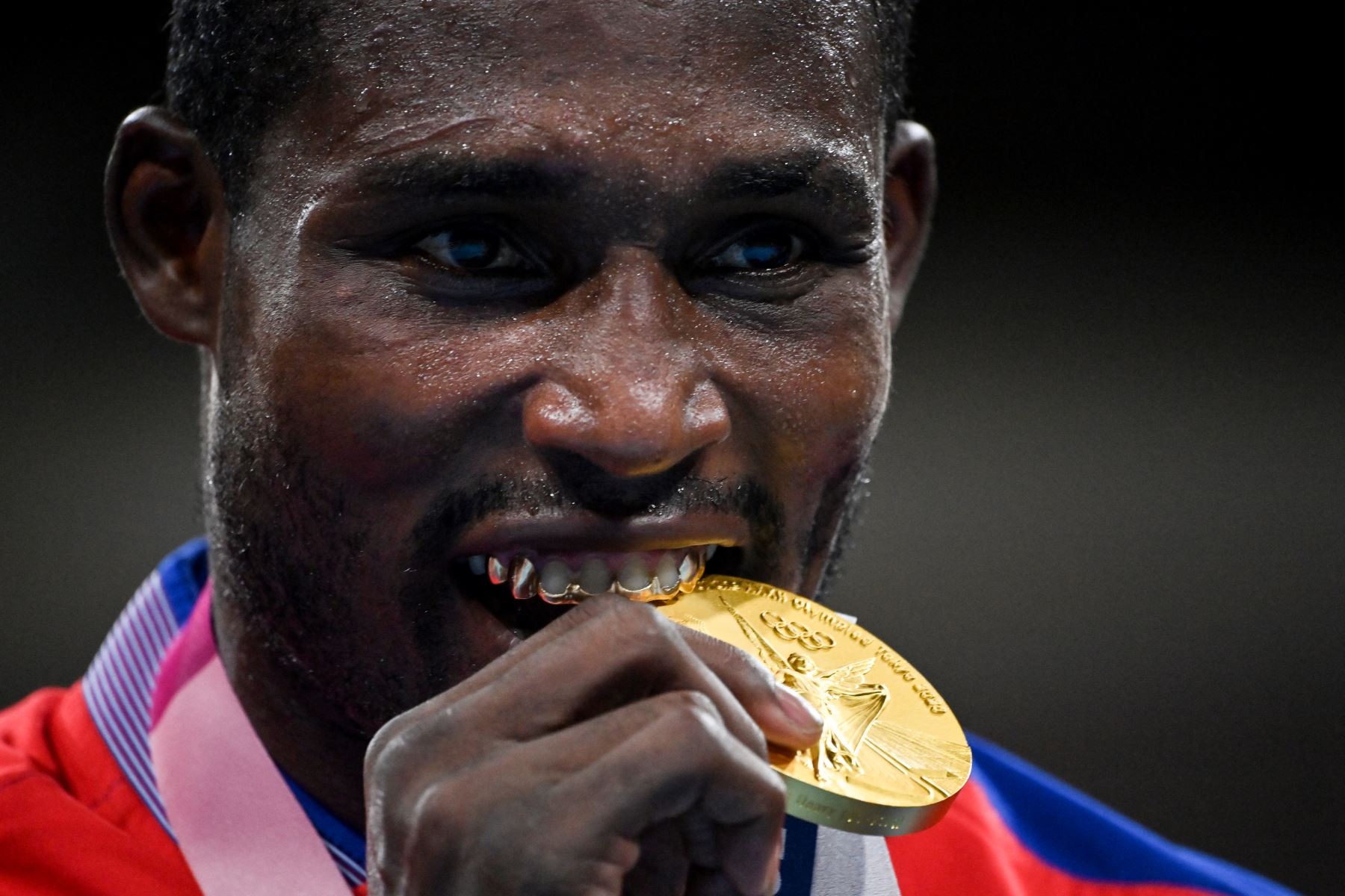 Julio La Cruz, medallista de oro de Cuba, muerde su medalla de oro en el podio después de la pelea final de boxeo masculino pesado (81-91 kg) durante los Juegos Olímpicos de Tokio 2020 en el Kokugikan Arena de Tokio el 6 de agosto de 2021. Foto: AFP