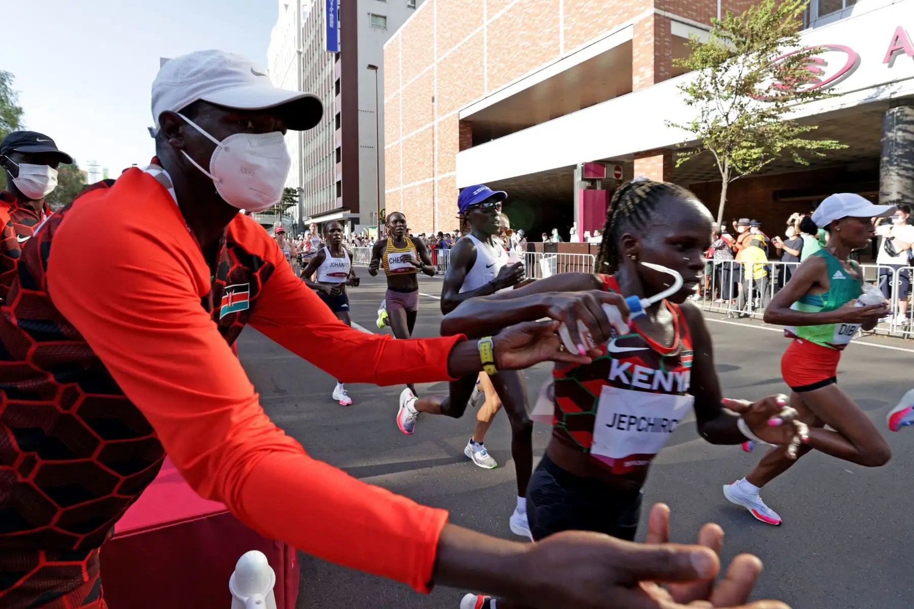 Peres Jepchirchir de Kenia recoge su botella de bebida del oficial keniano mientras compite en la final del maratón femenino durante los Juegos Olímpicos de Tokio 2020 en el Parque Sapporo Odori en Sapporo.
Foto: AFP