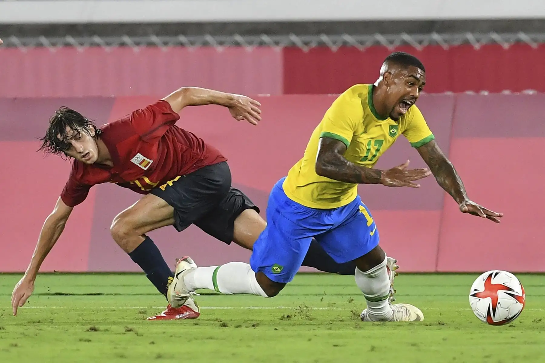 El español Bryan Gil comete una falta al brasileño Malcom Filipe durante el partido por la medalla de oro masculina de la competencia de fútbol por los Juegos Olímpicos de Tokio 2020. Foto: AFP