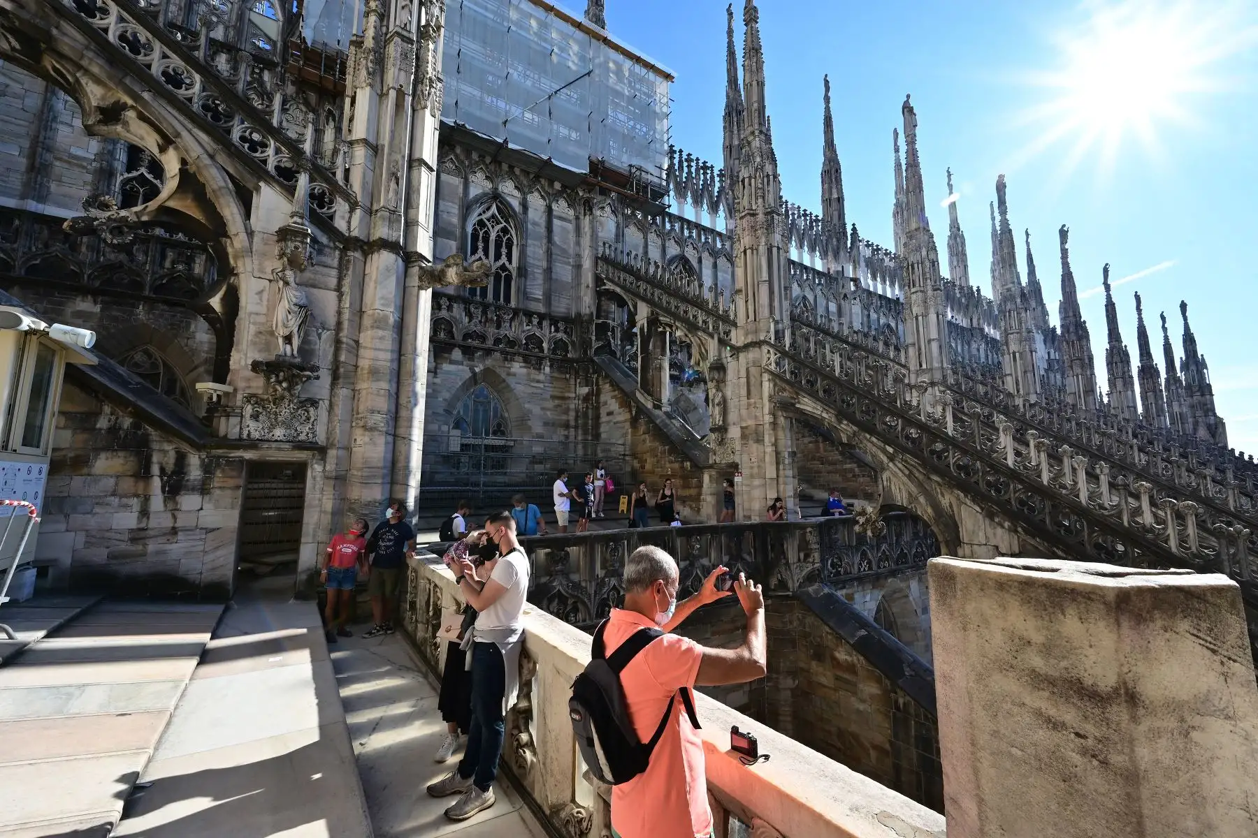Turistas caminan sobre el techo de la Catedral del Duomo en un día soleado en el centro de Milán, Italia. Foto: AFP