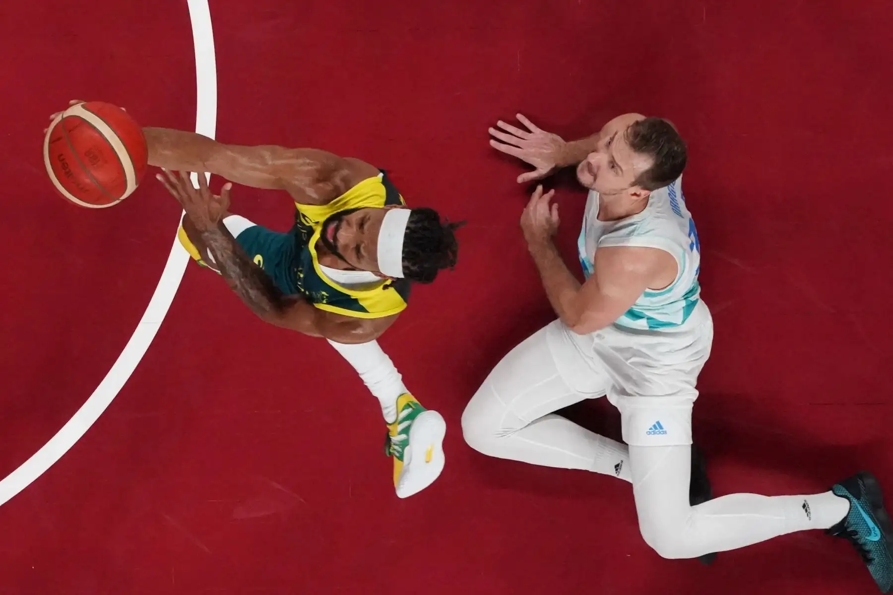 De Australia pasa a la canasta ante Zoran Dragic de Eslovenia en el partido de baloncesto masculino por la medalla de bronce entre Eslovenia y Australia durante los Juegos Olímpicos de Tokio 2020 en el Saitama Super Arena en Saitama el 7 de agosto de 2021. Foto: AFP