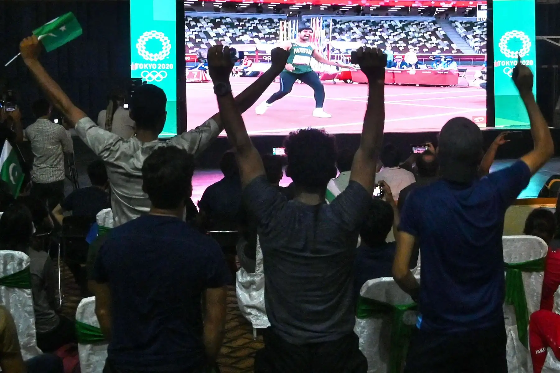 Los partidarios del atleta de Pakistán Arshad Nadeem ven los Juegos Olímpicos de Tokio 2020 en una pantalla mientras compite en la final masculina de lanzamiento de jabalina, en Lahore el 7 de agosto de 2021. Foto: AFP