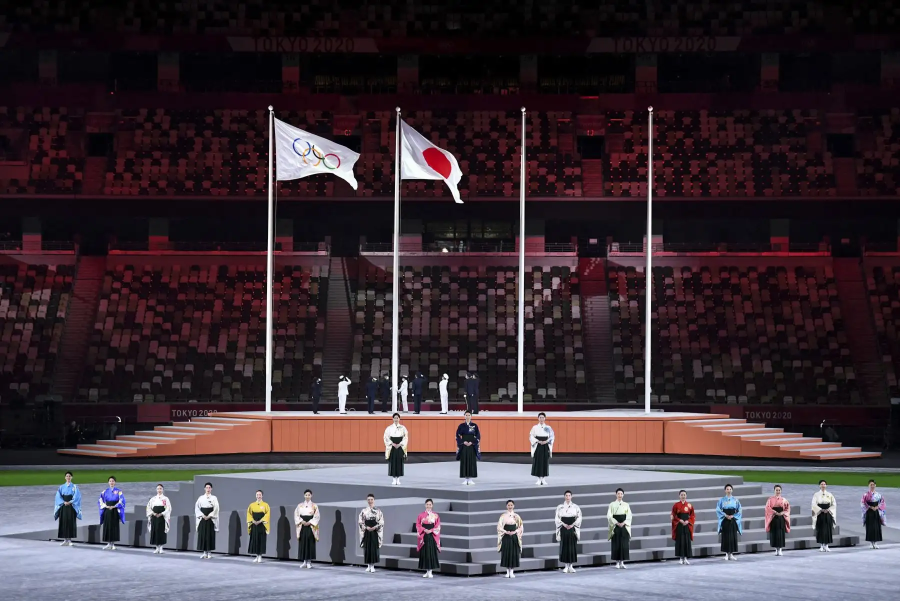 Los artistas cantan el himno nacional japonés mientras se iza la bandera olímpica y la bandera de Japón durante la ceremonia de clausura de los Juegos Olímpicos de Tokio 2020. Foto: AFP