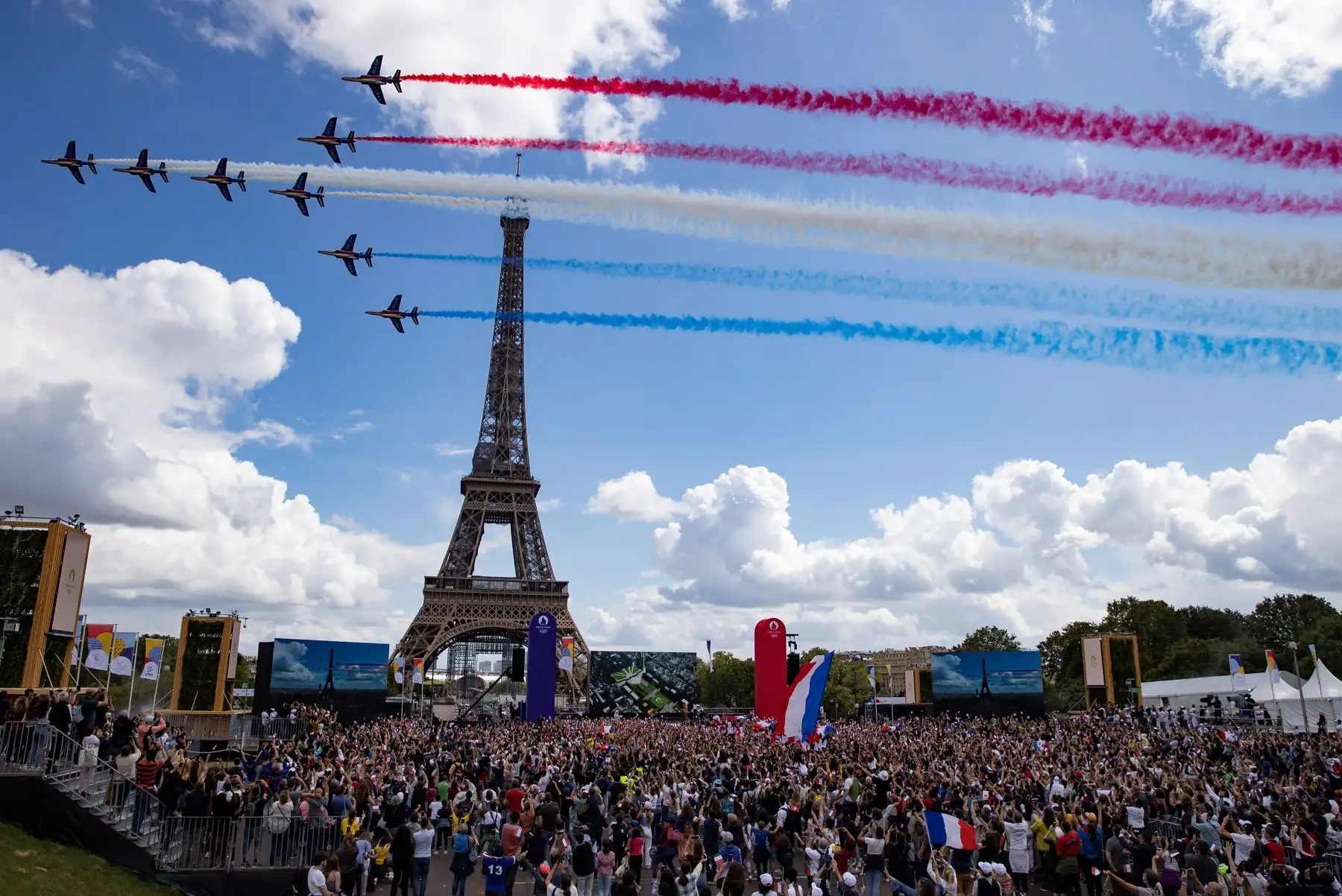 Alphajets de la Patrulla de Francia sobrevuelan la Torre Eiffel mientras una multitud se reúne durante una transmisión de la ceremonia de traspaso olímpico entre los Juegos Olímpicos de Tokio 2020 a París 2024. Foto: EFE