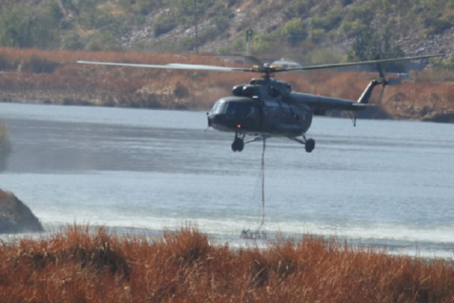Los helicópteros arrojan el agua de manera coordinada, no obstante brigadistas de bomberos forestales, comuneros, voluntarios, miembros de Serenazgo y de la Policía Nacional amagan focos de calor con "mata fuegos" y rastrillos.
