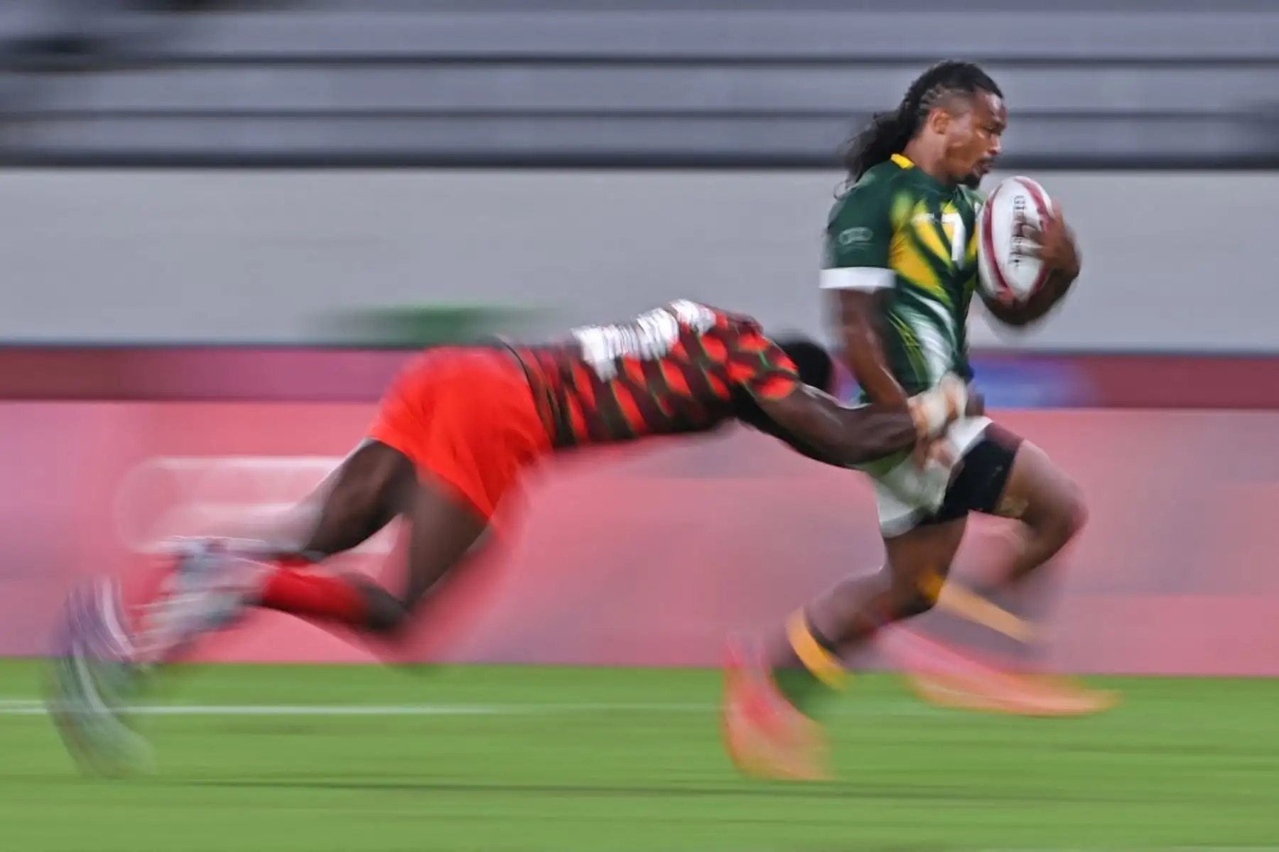 El sudafricano Branco du Preez es abordado por el keniano Willy Ambaka en el partido de rugby sevens del grupo C masculino entre Sudáfrica y Kenia durante los Juegos Olímpicos de Tokio 2020. Foto: AFP