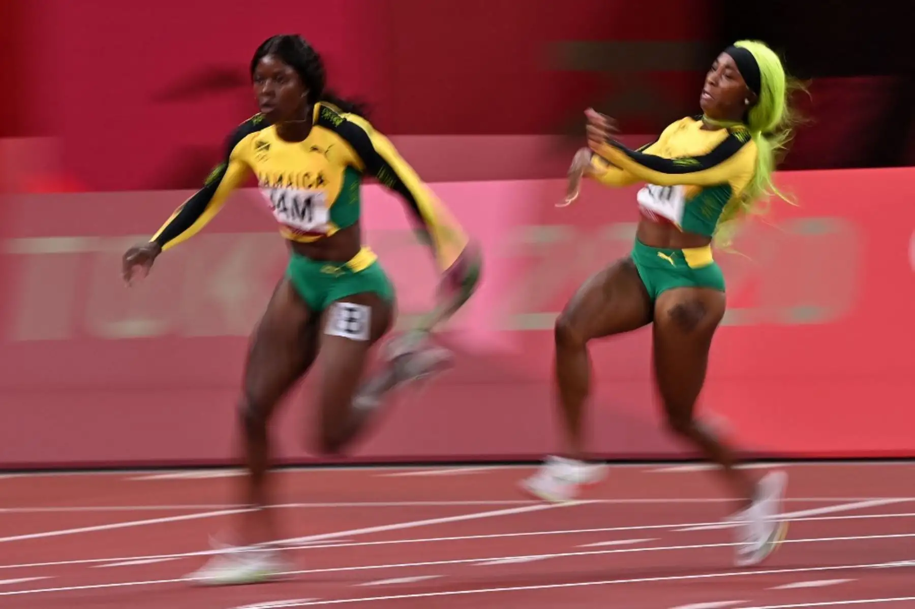 Shelly-Ann Fraser-Pryce entrega el relevo a Shericka Jackson, ambas de Jamaica, en la última entrega durante la final femenina de relevos. Foto : AFP