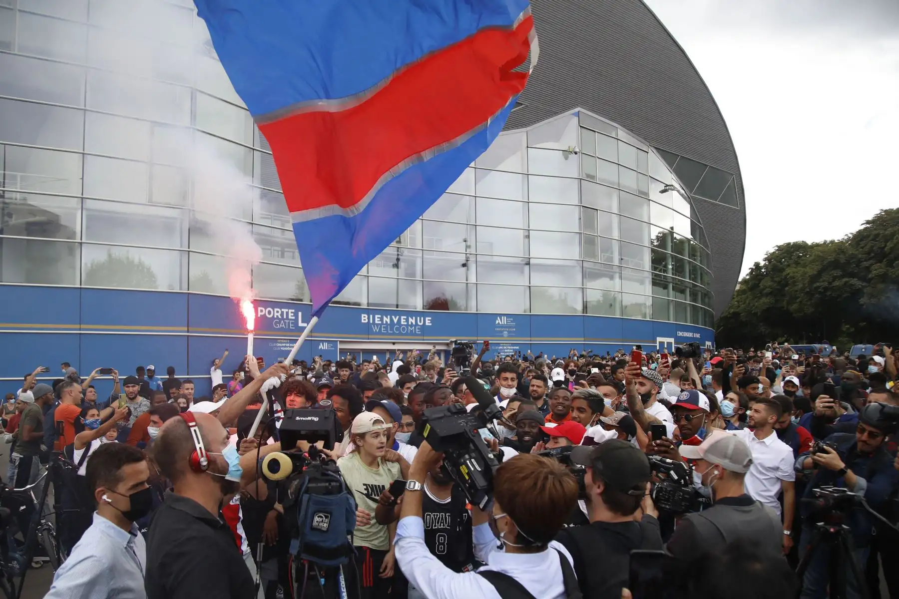 Los aficionados vitorean fuera del estadio Parc des Princes del club de fútbol francés Paris Saint-Germain, después de que el futbolista argentino Lionel Messi aterrizara en el aeropuerto de Le Bourget, cerca de París. 
Foto: AFP