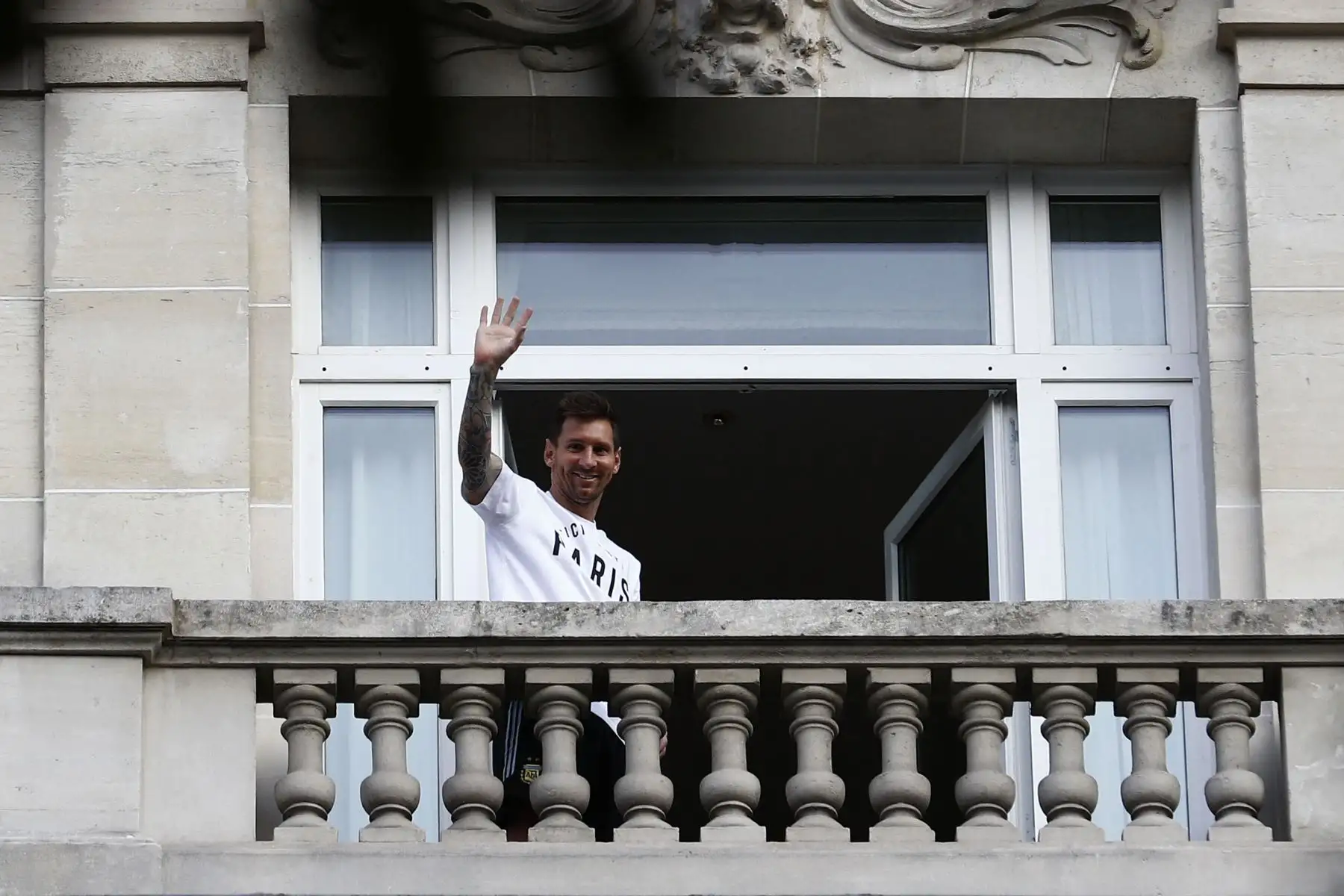 El jugador de fútbol argentino Lionel Messi saluda a los fanáticos desde un balcón del hotel Royal Monceau en París.
Foto: AFP