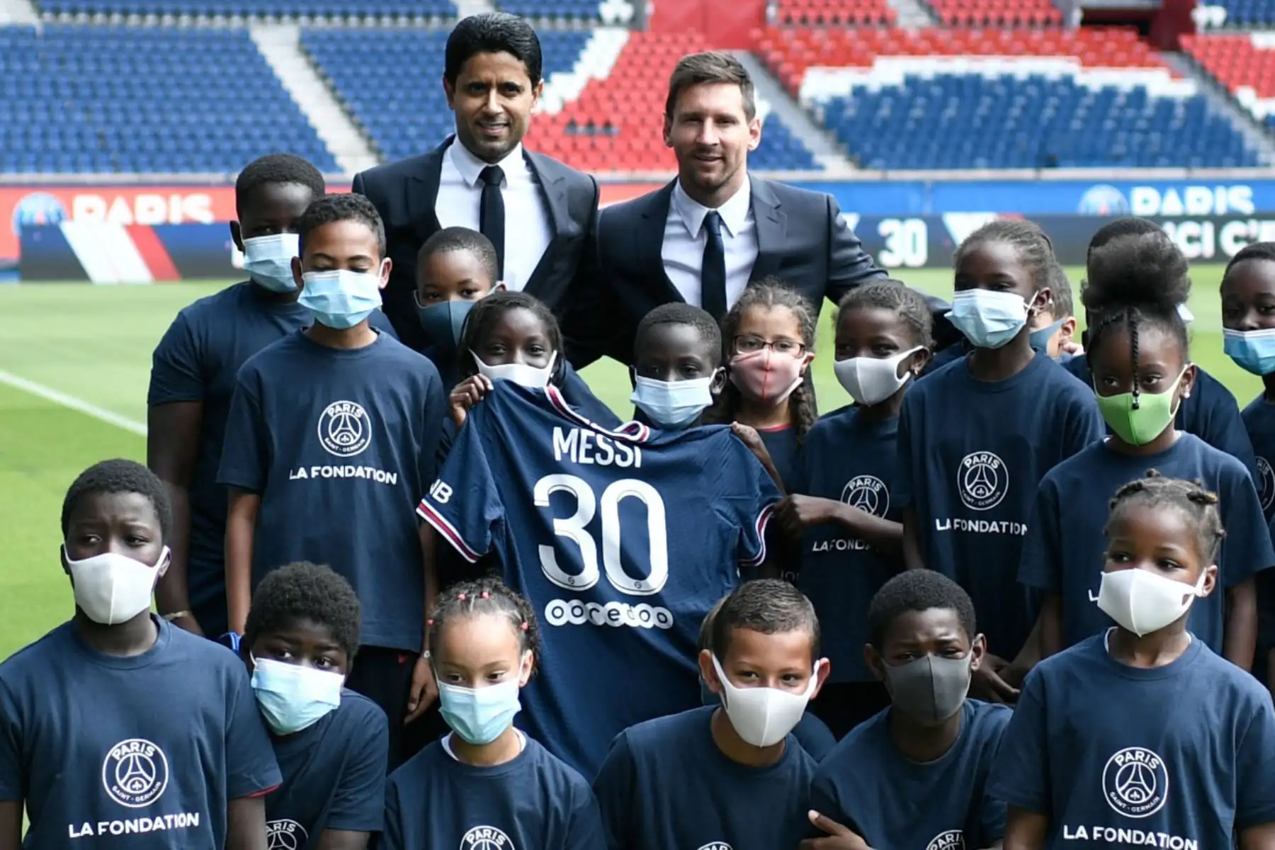 El presidente qatarí del Paris Saint-Germain, Nasser Al-Khelaifi (parte posterior C), posa junto al jugador de fútbol argentino Lionel Messi (parte posterior R) mientras los niños sostienen su camiseta con el número 30 mientras están de pie en el campo durante una conferencia de prensa en el club de fútbol francés.

Foto:AFP