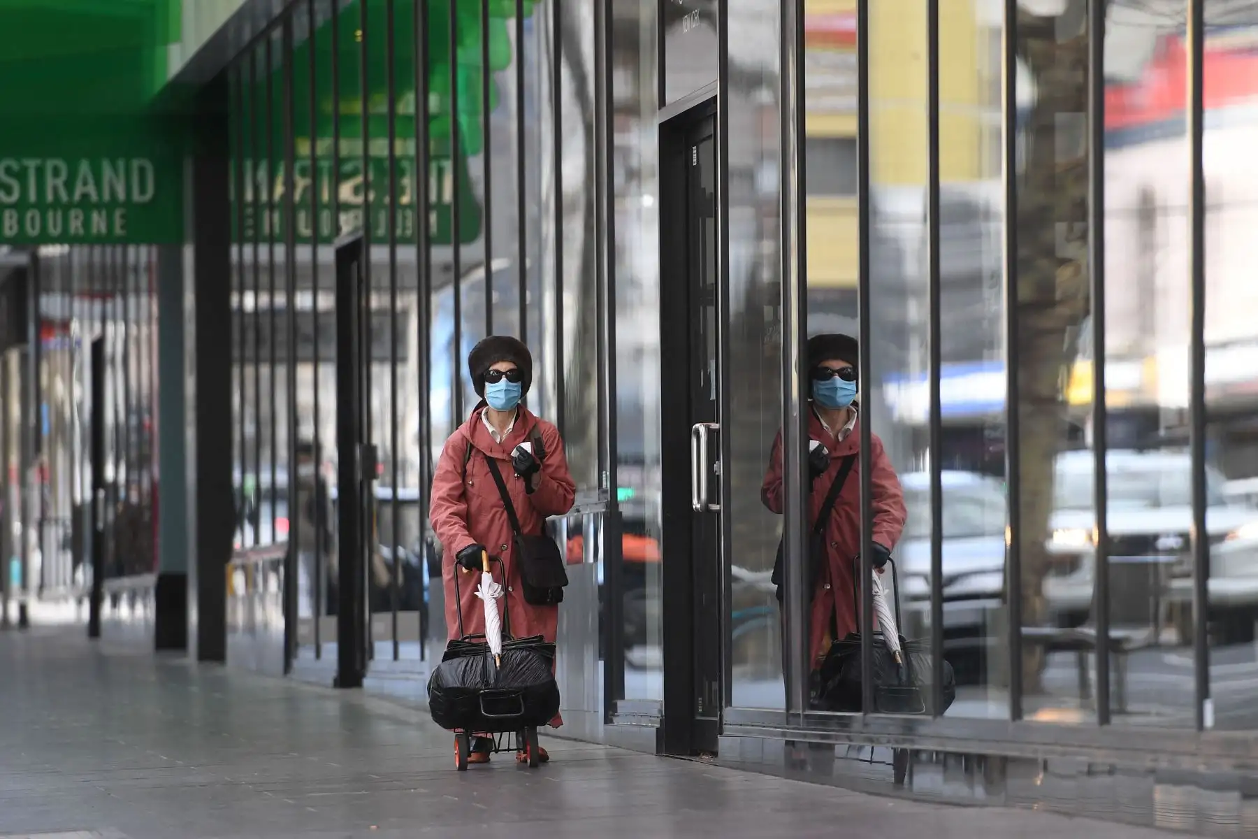 Una mujer camina por una calle tranquila en el distrito comercial central de Melbourne, donde las autoridades han anunciado orden de confinamiento. 
Foto: AFP