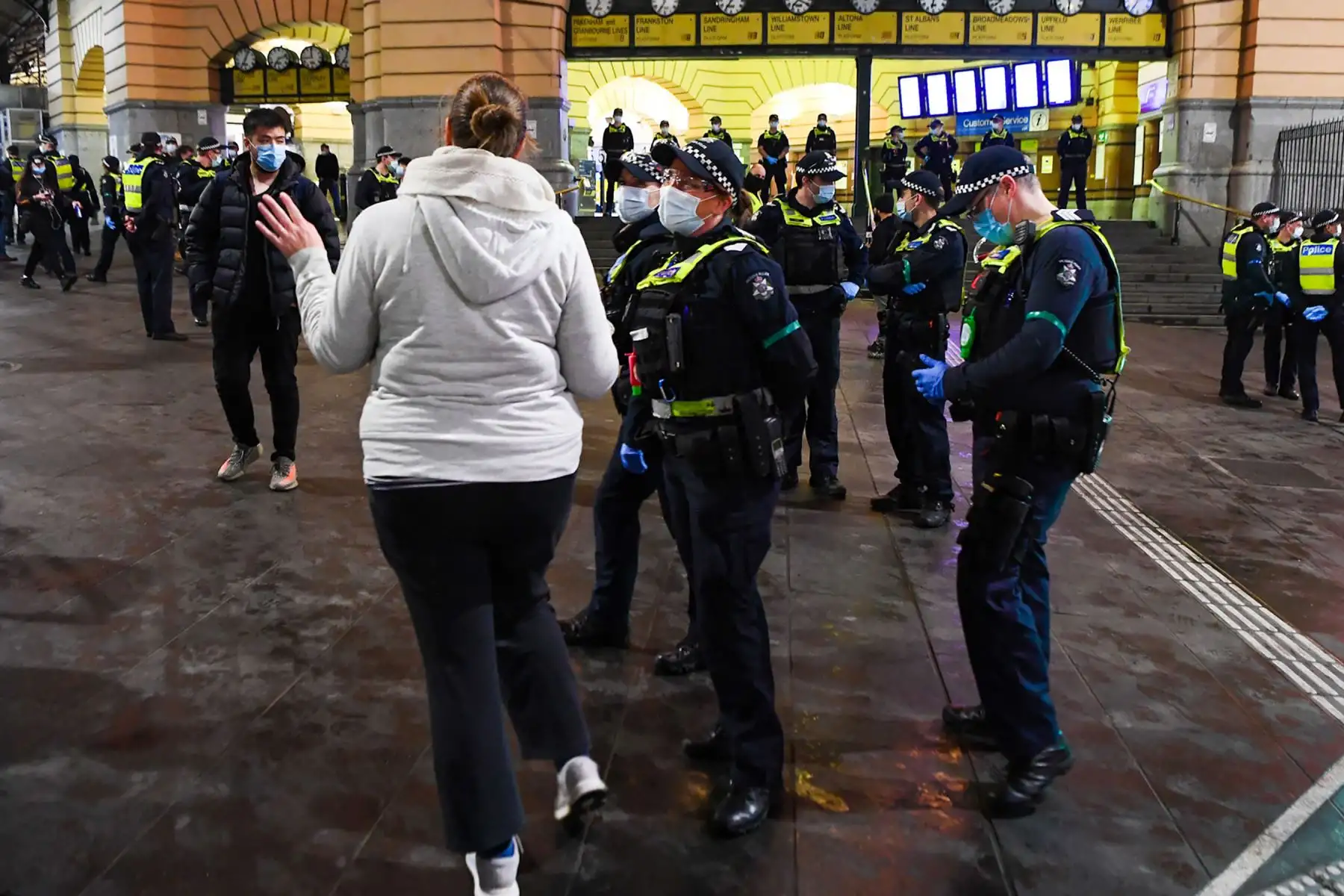 Un oficial de policía habla con una mujer mientras la policía patrulla en un mitin antibloqueo en Melbourne.
Foto: AFP