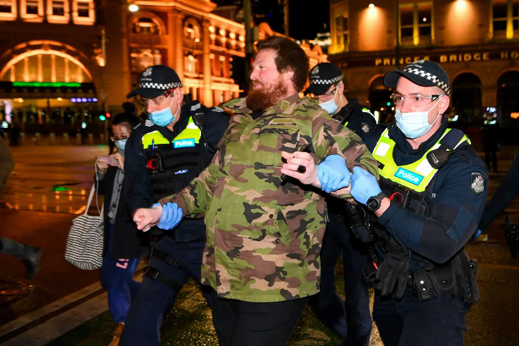 La policía detiene a un hombre en un mitin contra el bloqueo en Melbourne.
Foto: AFP