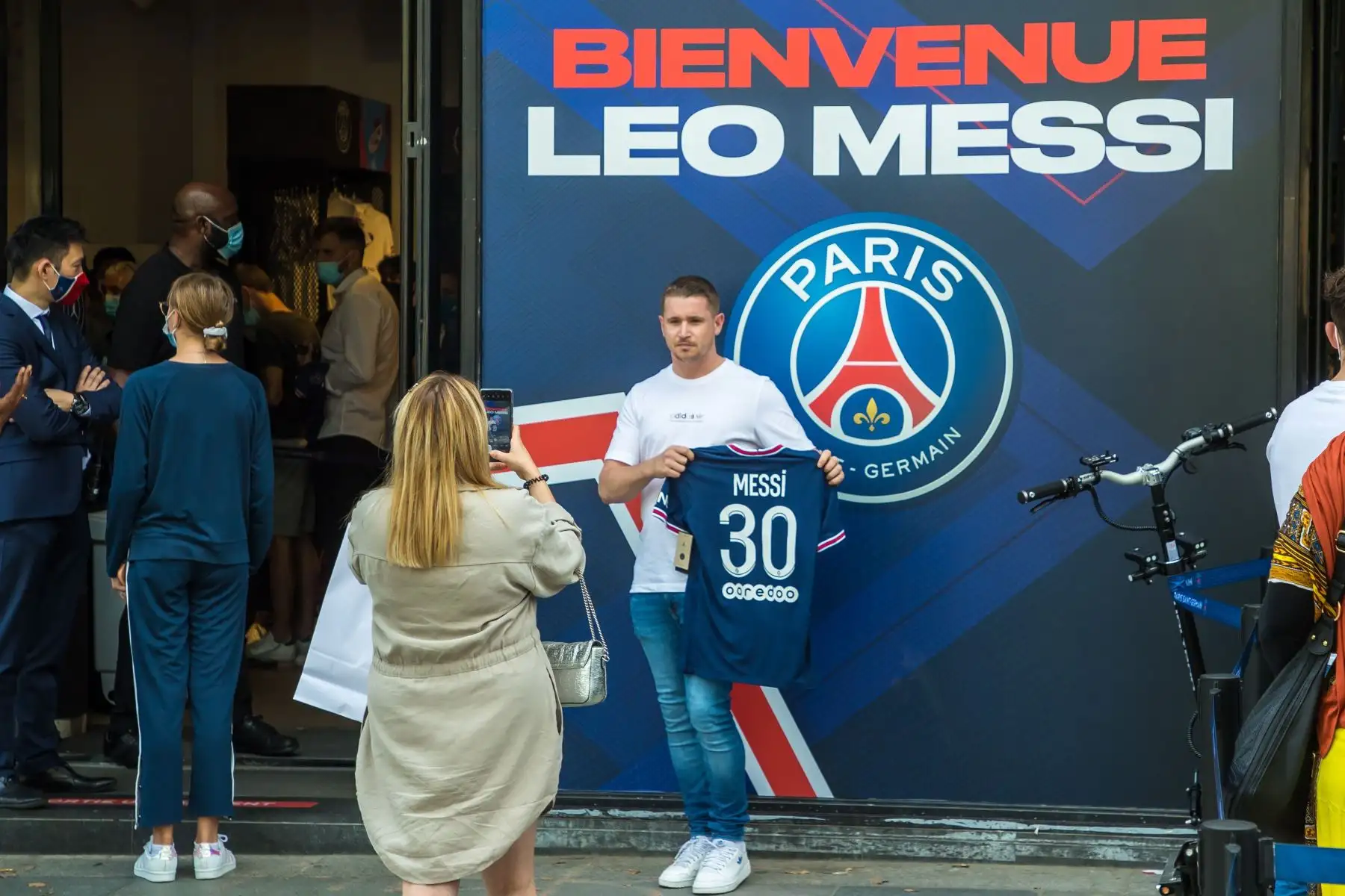 Los aficionados posan para las fotografías después de comprar la nueva camiseta 