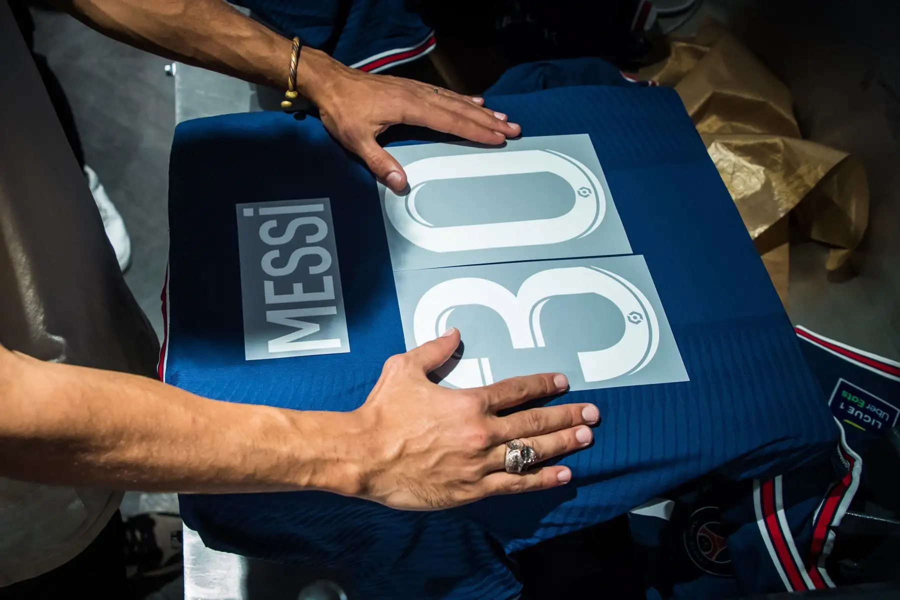 Un empleado agita las letras de la nueva camiseta 