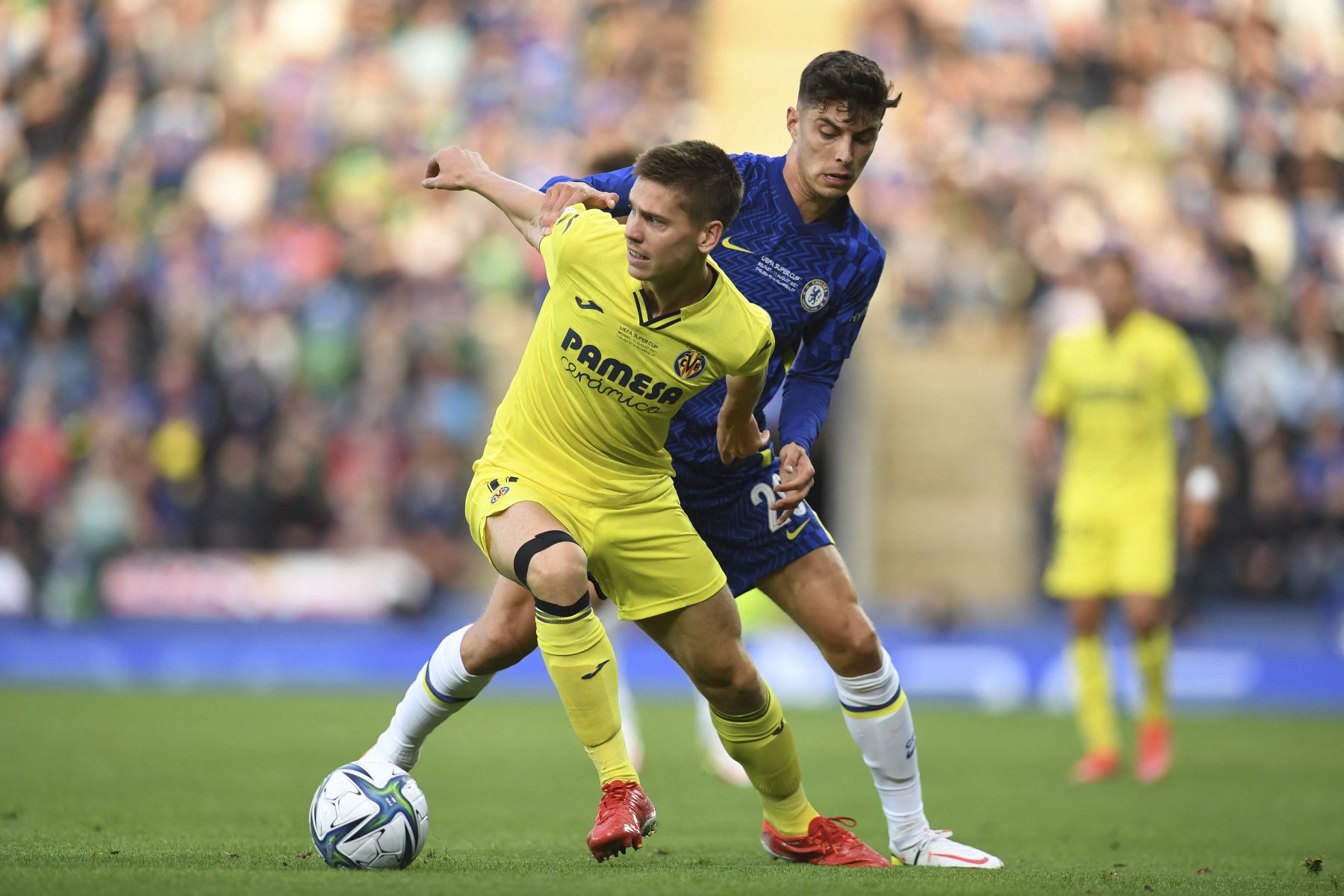 El defensor argentino del Villarreal Juan Foyth intenta contener al mediocampista alemán del Chelsea Kai Havertz durante partido por la Supercopa de la UEFA, en el Windsor Park de Belfast. Foto: AFP