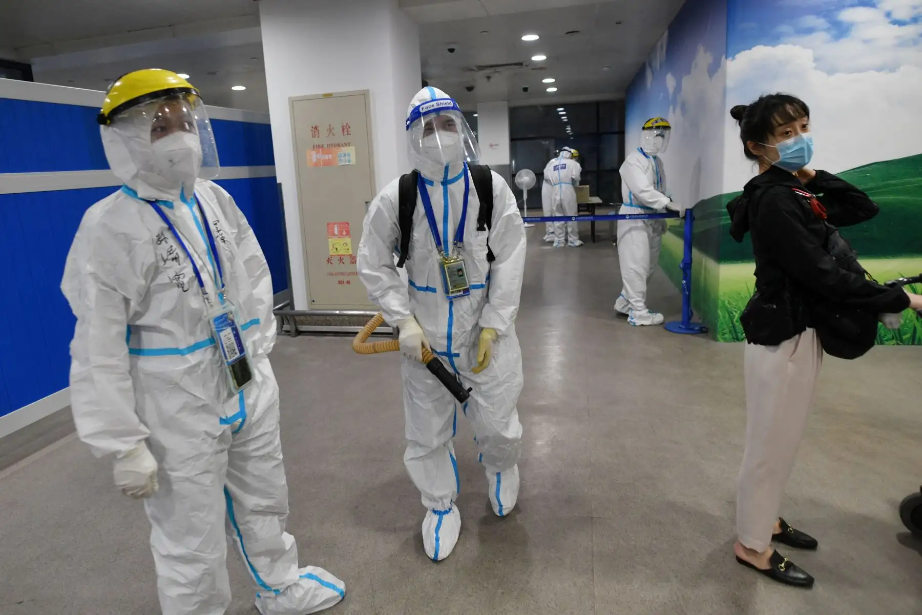 Trabajadores con ropa protectora como precaución contra el coronavirus desinfectan un área donde los pasajeros internacionales que llegan esperan ser llevados a un hotel de cuarentena, en el aeropuerto de Pudong en Shanghai.
Foto: AFP