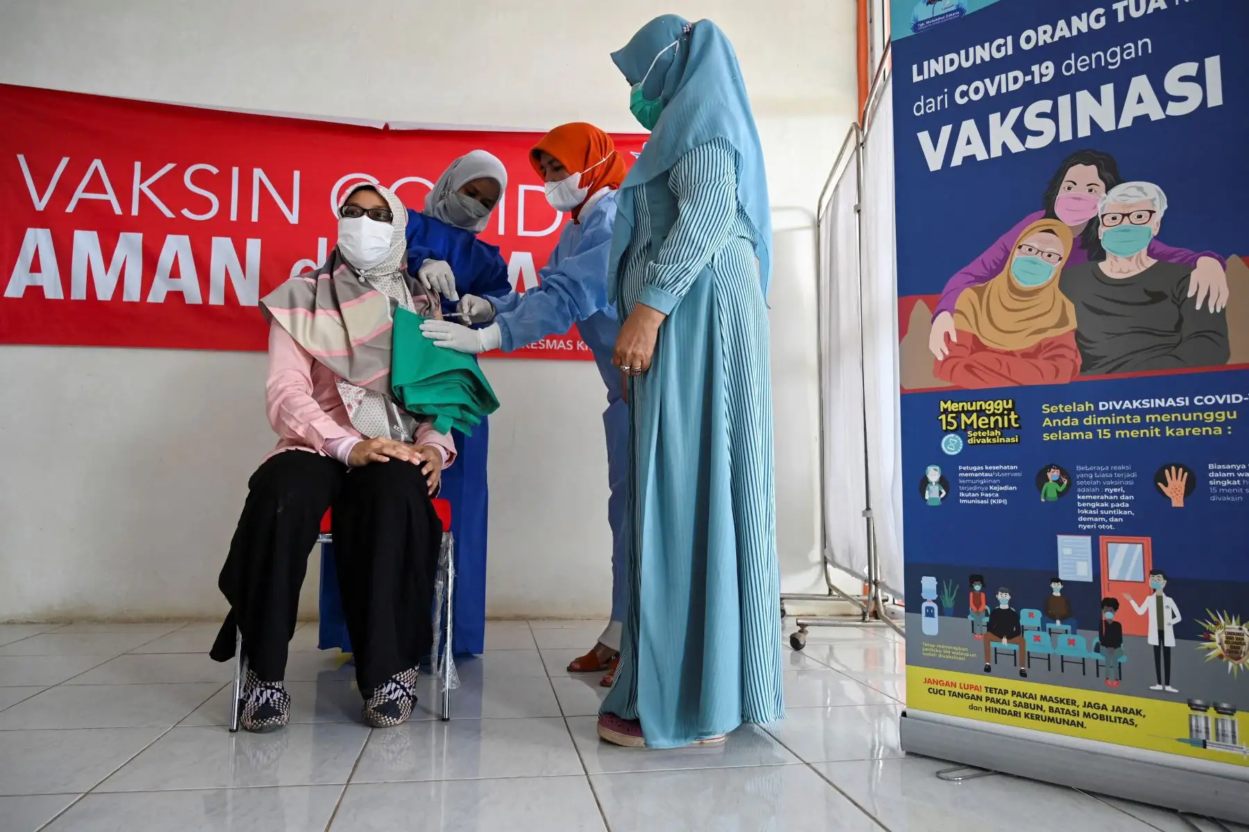 Una mujer recibe una dosis de la vacuna Moderna covid-19, donada a Indonesia por Estados Unidos, durante una campaña de vacunación de refuerzo en Barona Jaya, en las afueras de Banda Ace.
Foto: AFP