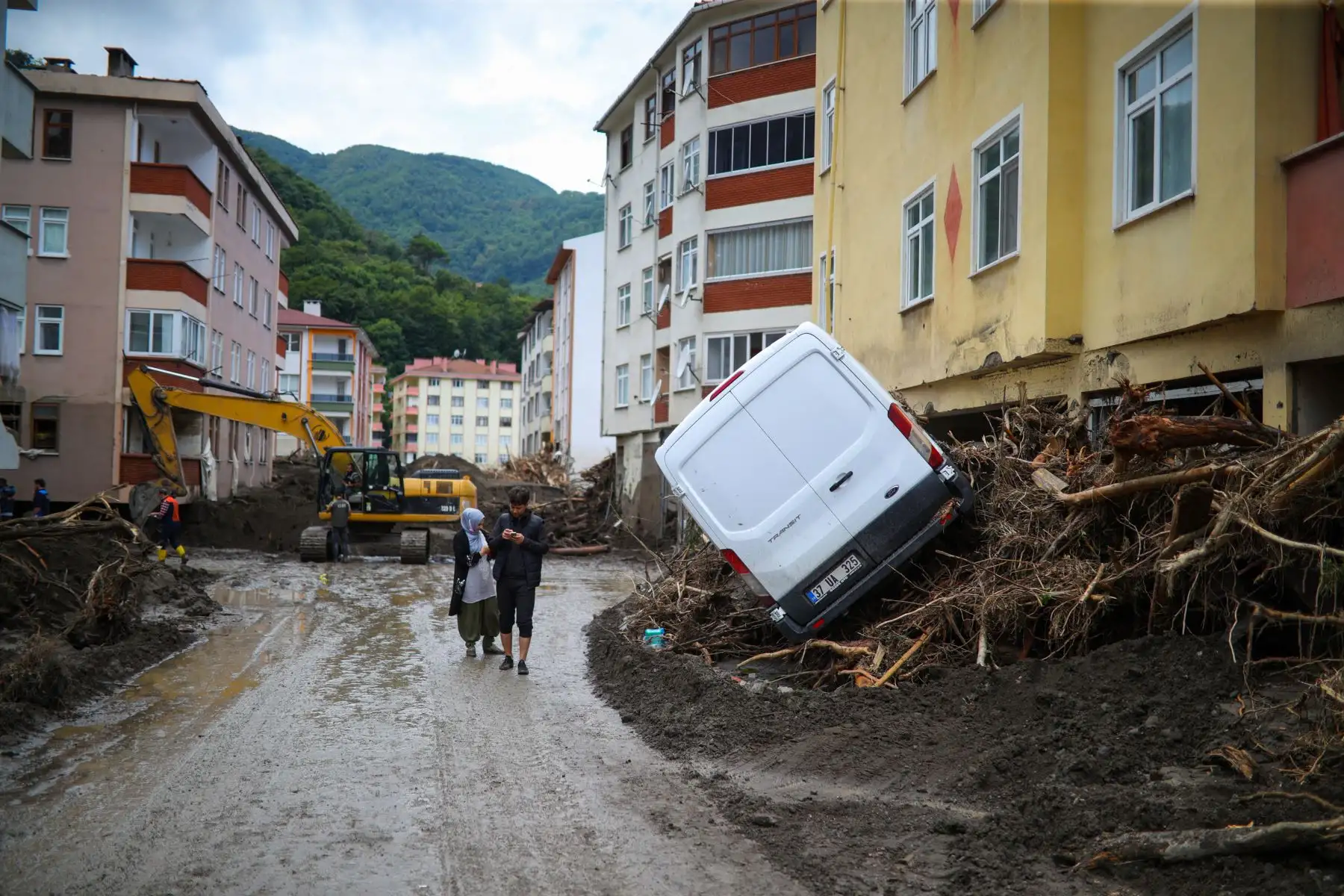 Un hombre y una mujer caminan por una calle embarrada después de que las inundaciones destruyeran parte de la ciudad de Bozkurt, en  Kastamonu, en la región del Mar Negro, Turquía. Foto: AFP