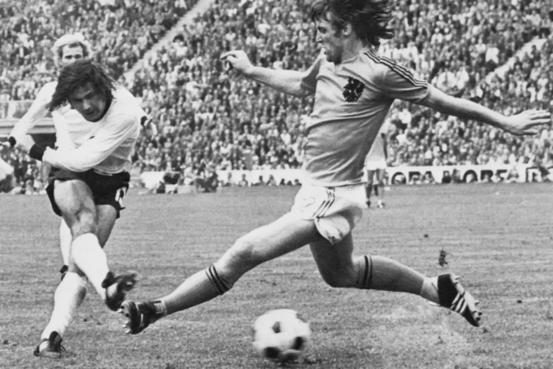 El delantero de Alemania Occidental, Gerd Mueller (izq.), marca el segundo gol de su equipo a pesar de haber sido presionado por el defensa holandés Rudi Krol en Múnich, durante la final de la Copa Mundial de Fútbol. Foto: AFP