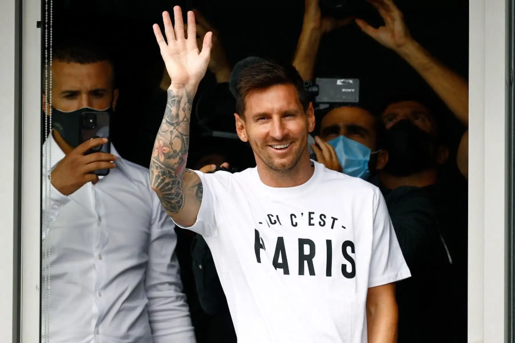 El futbolista argentino Lionel Messi saluda a los aficionados del PSG desde una ventana después de aterrizar el 10 de agosto de 2021 en el aeropuerto de Le Bourget, al norte de París. Foto: AFP