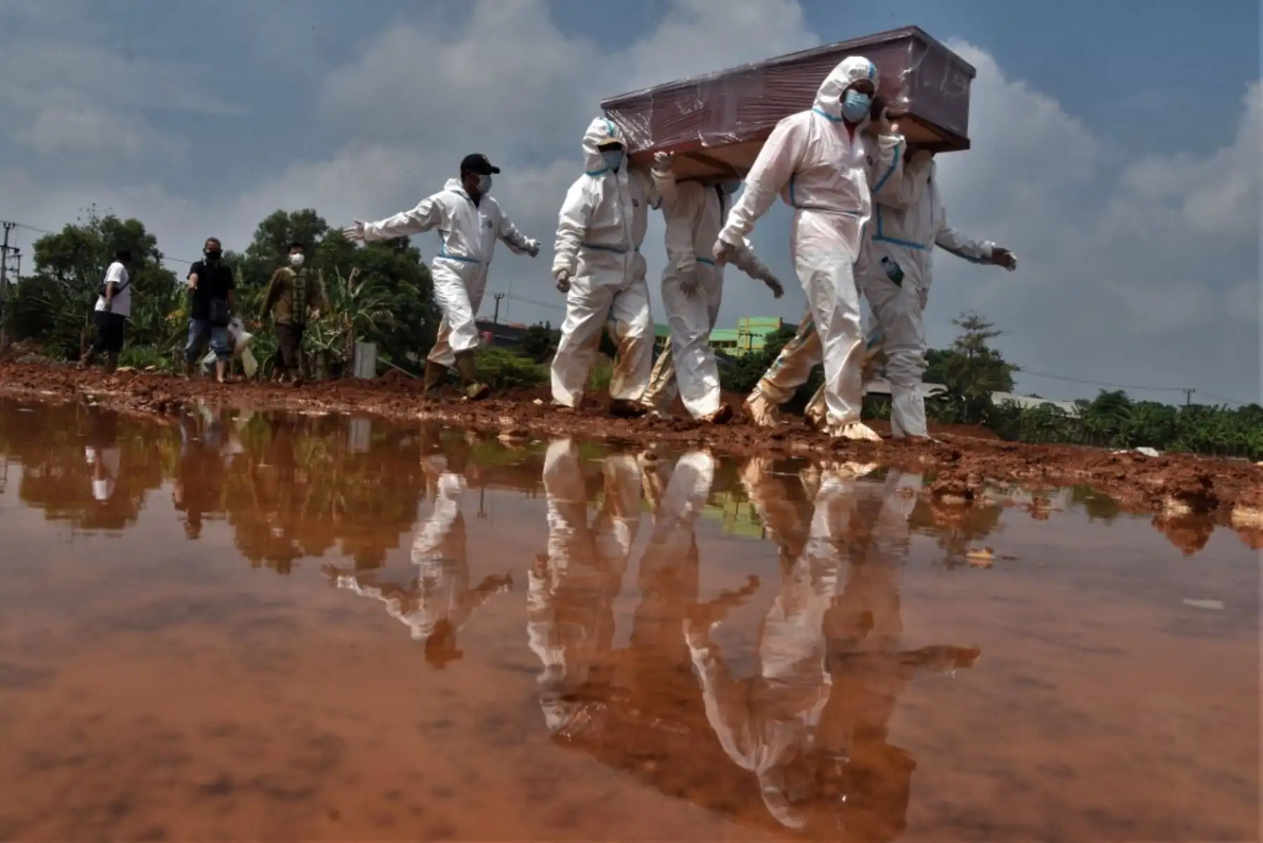 Los excavadores de tumbas llevan el ataúd de una víctima que murió por el coronavirus Covid-19 para su entierro en un cementerio en Bekasi el 10 de agosto de 2021. Foto: AFP