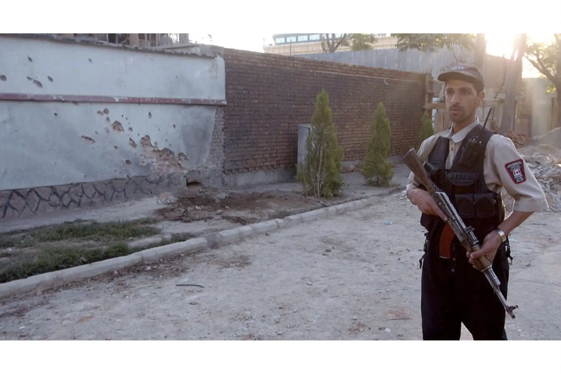 Un oficial de seguridad afgano monta guardia afuera de la embajada canadiense luego de un ataque con cohetes en Kabul. Foto: AFP