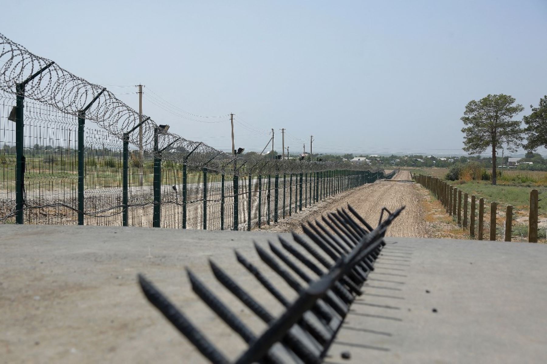 Esta fotografía tomada el 15 de agosto de 2021 muestra un muro de alambre de púas cerca de un puesto de control policial, a dos kilómetros del "Puente de la Amistad" sobre el río Amu Darya, que separa Uzbekistán y Afganistán cerca de Termez. Foto: AFP