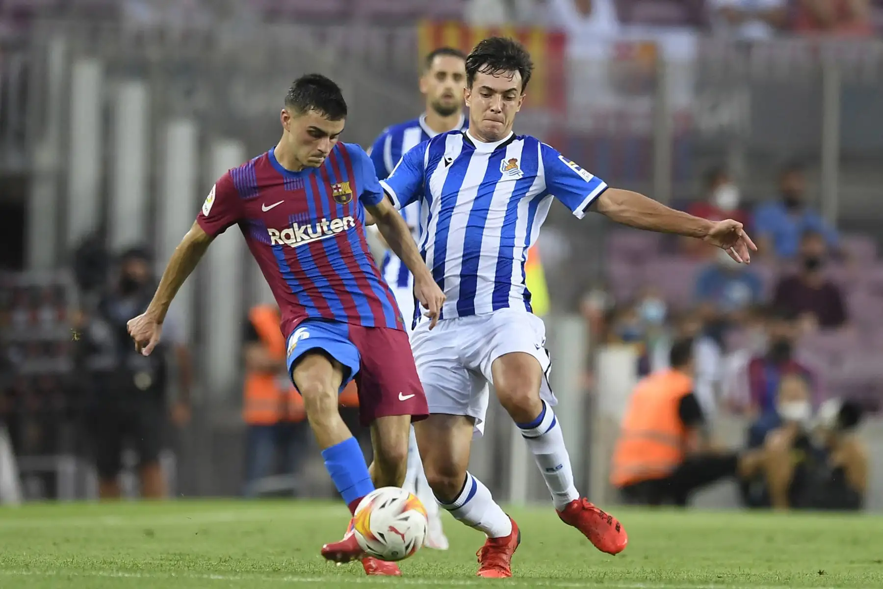 El centrocampista español del Barcelona, ​​Pedri, compite con el centrocampista español de la Real Sociedad, Martín Zubimendi, durante el partido de la Liga española, en el estadio Camp Nou. Foto: AFP