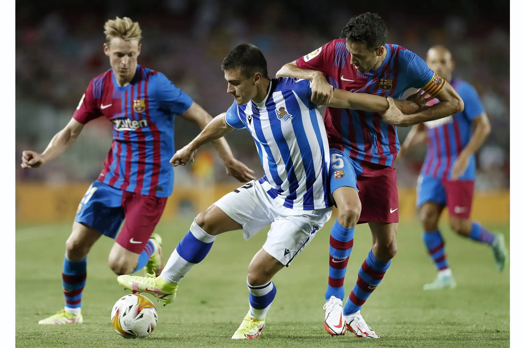 El centrocampista del FC Barcelona, Sergio Busquets,  lucha con Ander Barrenetxea de la Real Sociedad durante el partido de la primera jornada de LaLiga, en el Camp Nou. Foto: EFE
