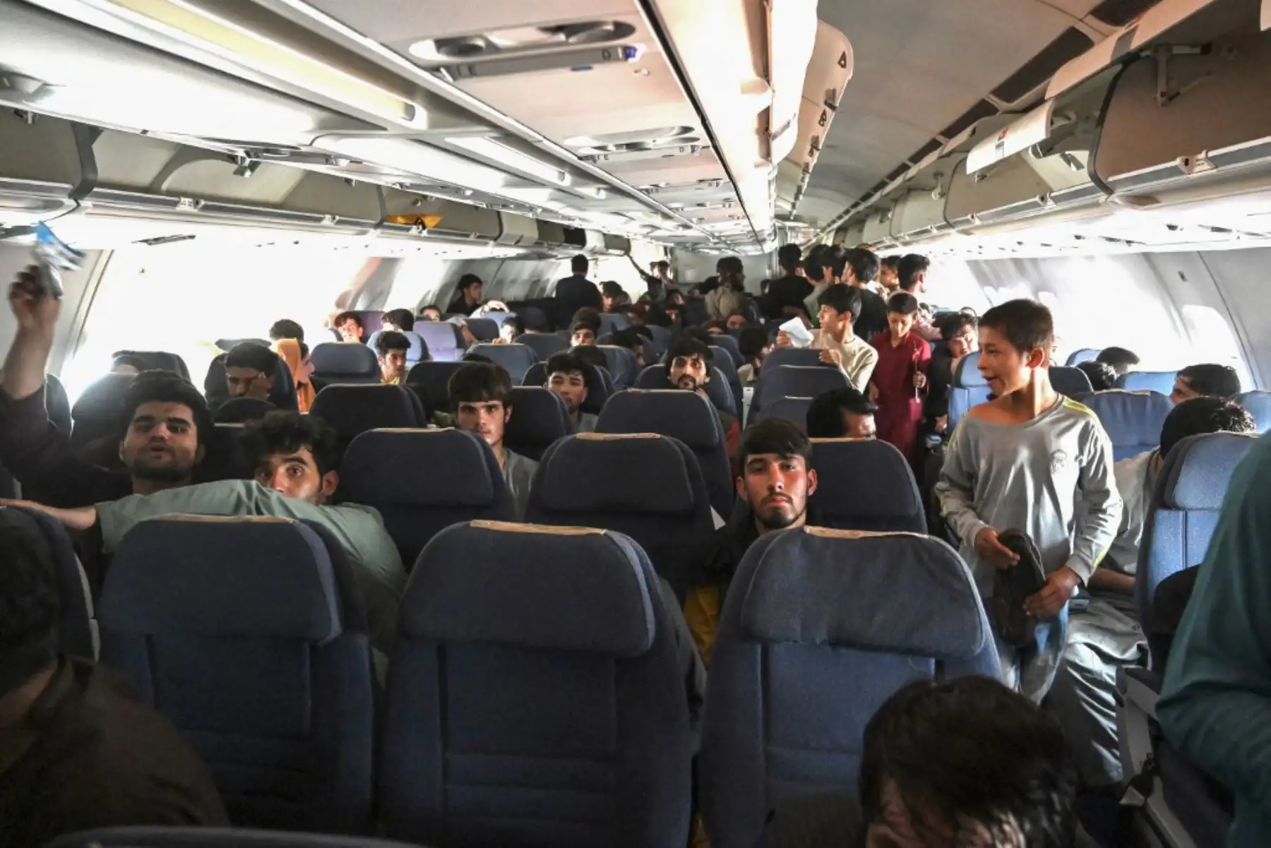 Afganos suben a un avión mientras esperan en el aeropuerto de Kabul  después del de la guerra de 20 años de Afganistán, mientras miles de personas asaltaron el aeropuerto de la ciudad tratando de huir de la temida marca de línea dura del grupo.

Foto: AFP