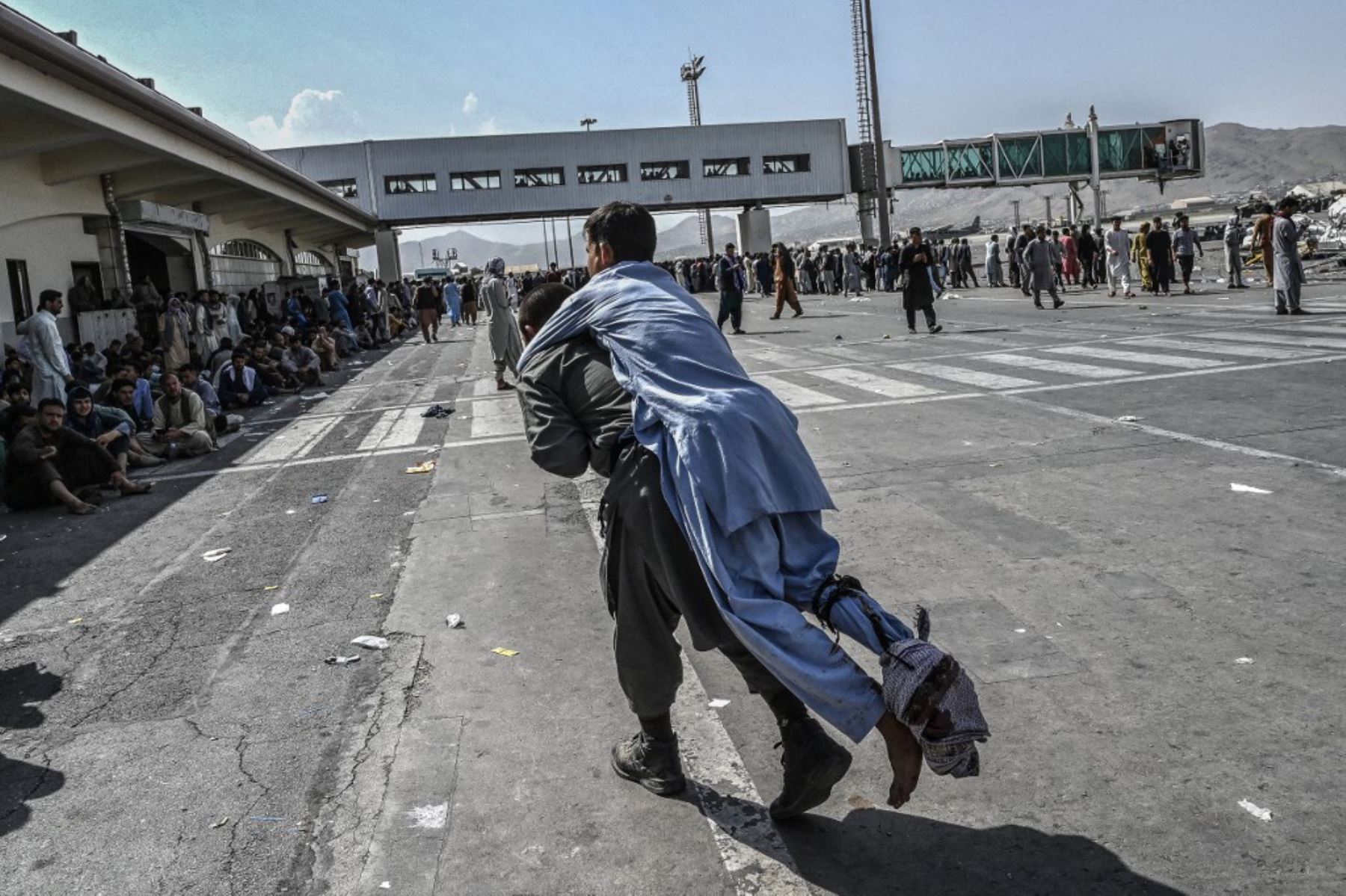 Pasajeros afganos esperan para salir del aeropuerto de Kabul después del final de la guerra de 20 años en Afganistán. Foto: AFP