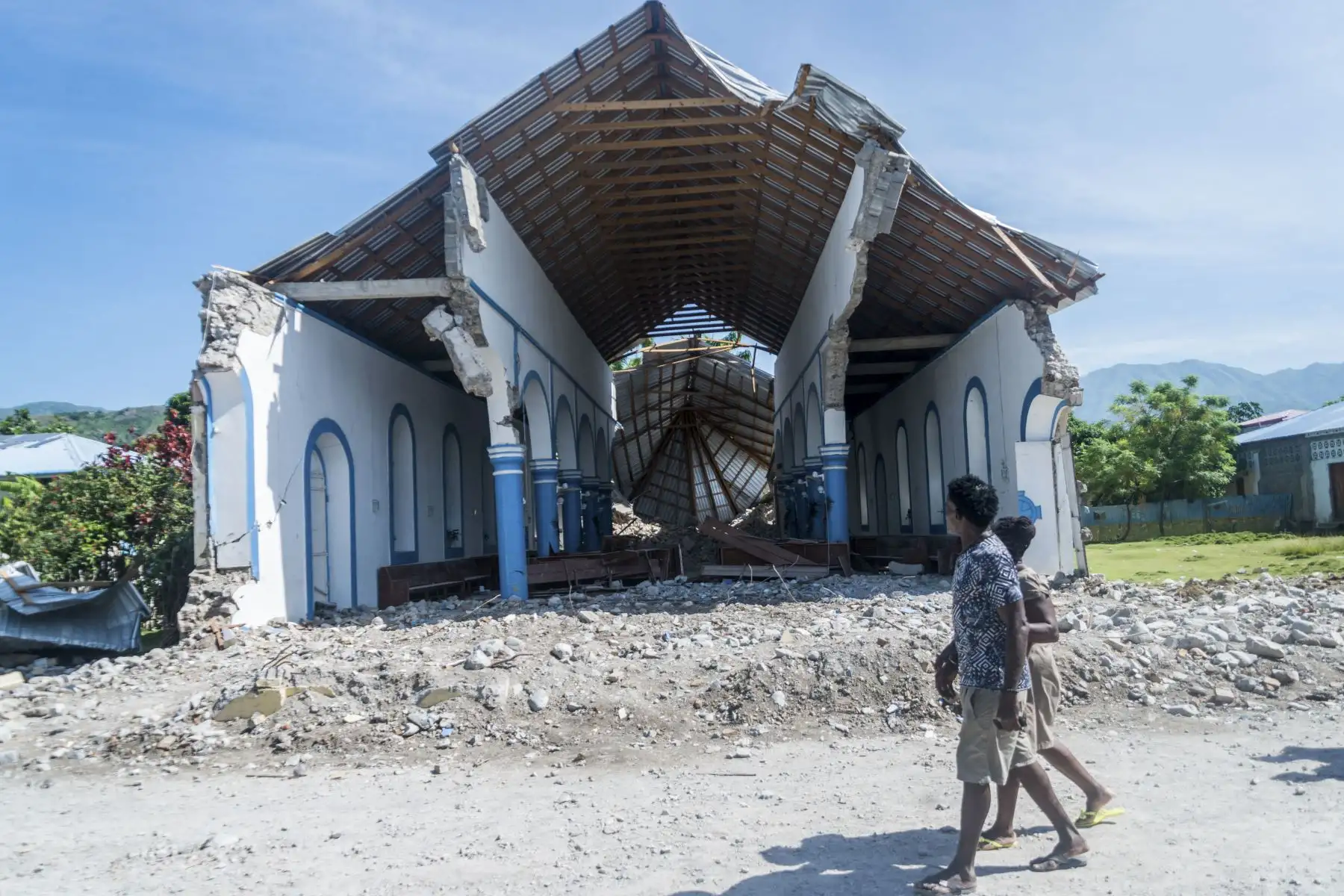 Dos haitianos pasan junto a una iglesia destruida durante un terremoto en Les Anglais. Al menos 1.297 personas murieron en el terremoto de magnitud 7,2 que se produjo el sábado a unos 60 kilómetros al oeste de la capital.
Foto: AFP