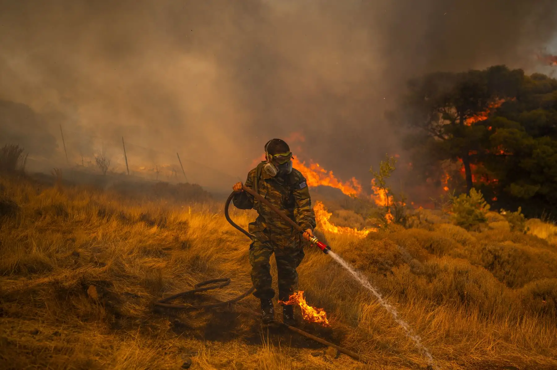 Un voluntario utiliza una manguera de agua para extinguir el incendio en el pueblo de Markati, cerca de Atenas, Grecia. Foto: AFP