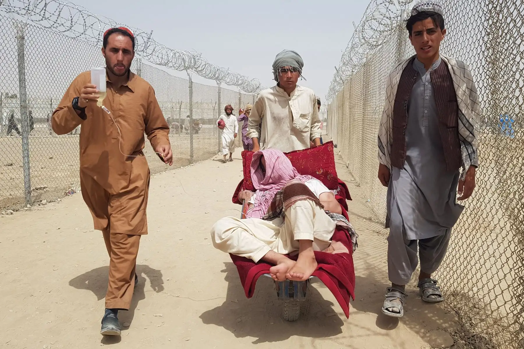 Un portero empuja una carretilla que transporta a un ciudadano afgano enfermo acompañado por su pariente cuando llegan a Pakistán en el puesto fronterizo entre Pakistán y Afganistán.

Foto: AFP