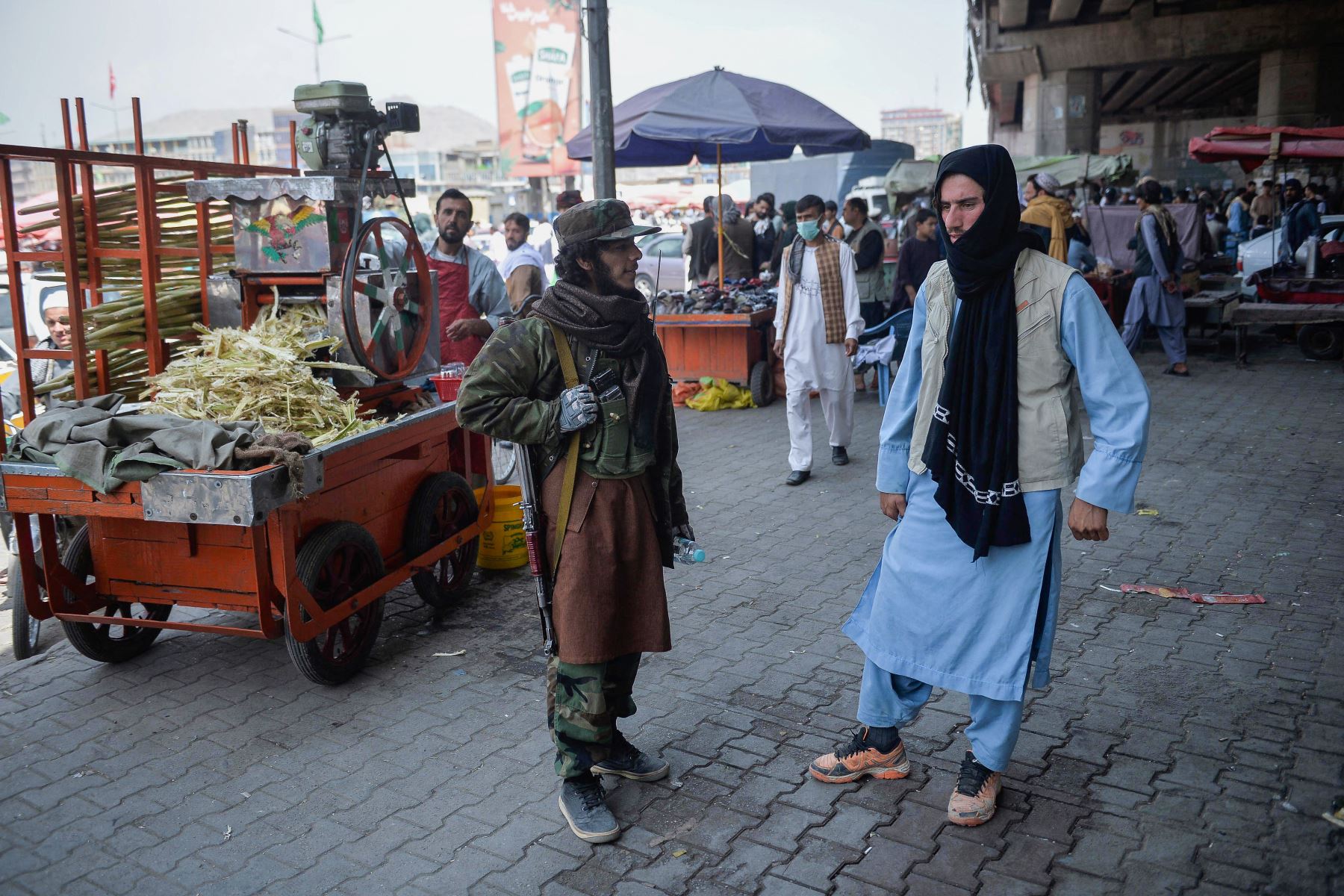 Un combatiente talibán junto a un quiosco que vende jugo de caña de azúcar en un área de mercado, se reunió con los afganos locales en el área de Kote Sangi de Kabul, después de que los talibanes tomaron el control de la capital tras el colapso del gobierno afgano.

Foto: AFP