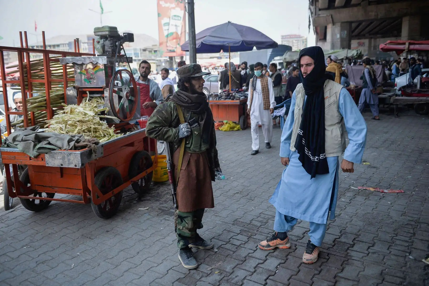 Un combatiente talibán junto a un quiosco que vende jugo de caña de azúcar en un área de mercado, se reunió con los afganos locales en el área de Kote Sangi de Kabul, después de que los talibanes tomaron el control de la capital tras el colapso del gobierno afgano.

Foto: AFP