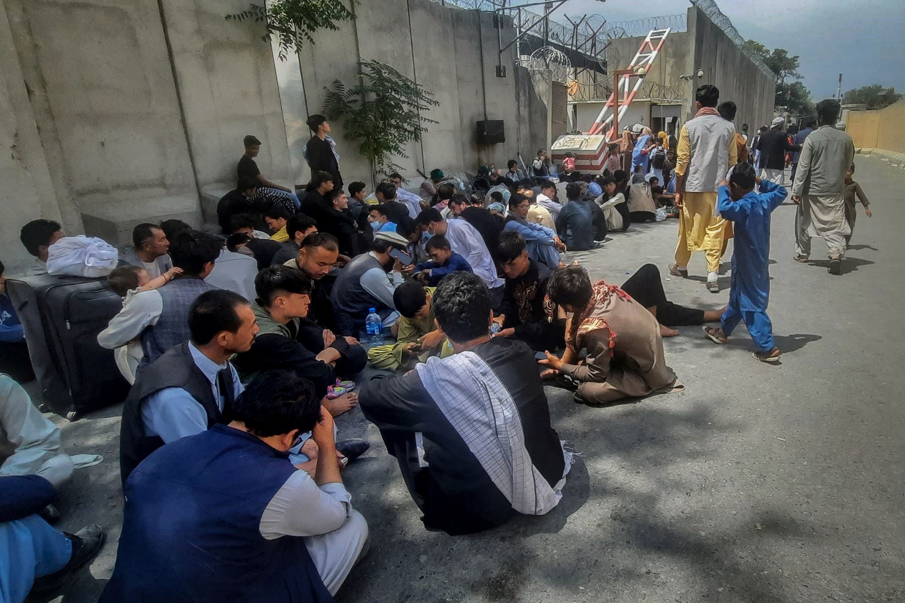 Los afganos se sientan frente a la embajada francesa en Kabul esperando salir de Afganistán. 

Foto: AFP