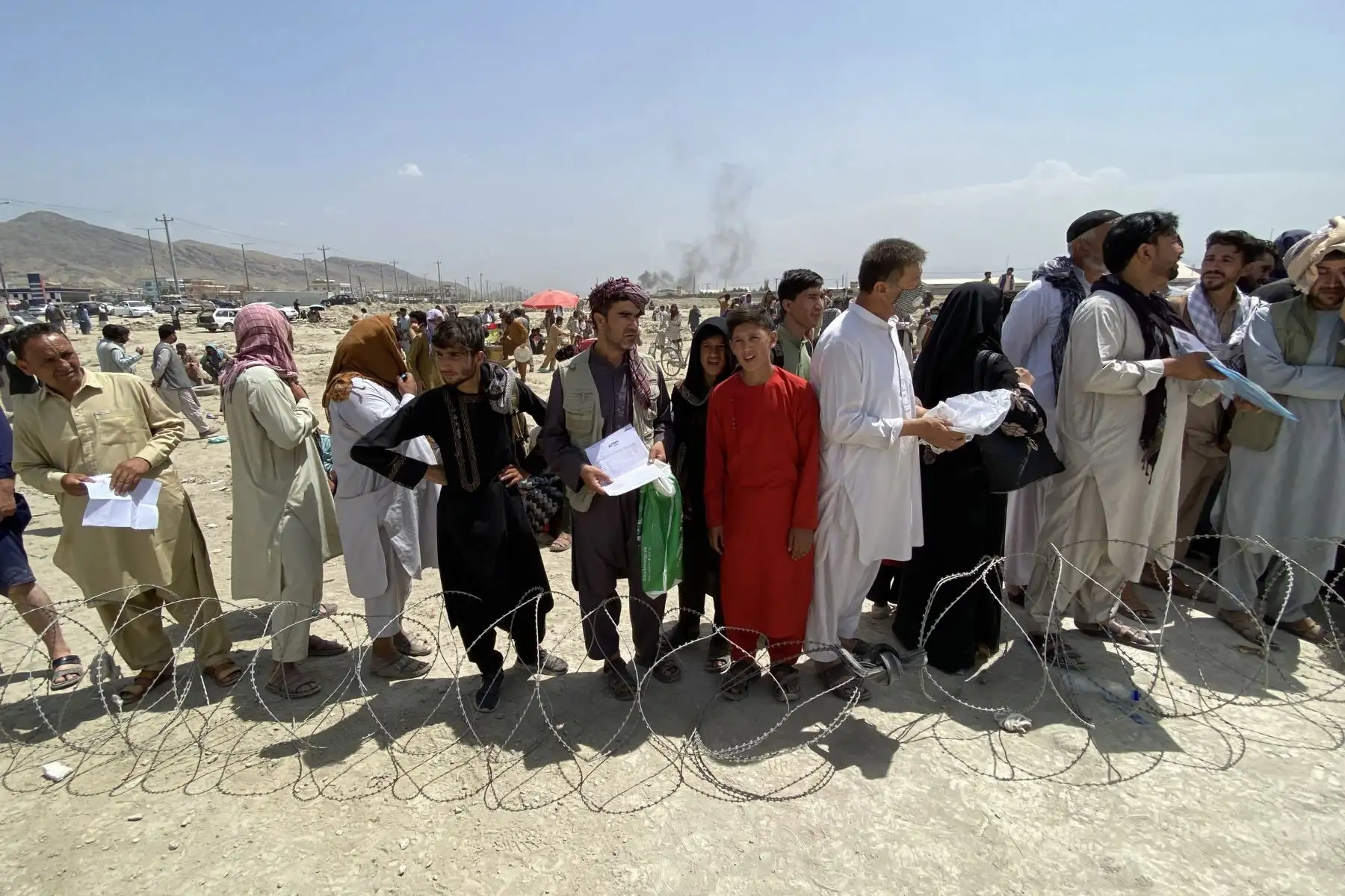 Afganos, incluidos los que trabajaron para los EE. UU., La OTAN, la Unión Europea y las Naciones Unidas en Afganistán, esperan frente al aeropuerto internacional Hamid Karzai para huir del país, después de que los talibanes tomaran el control de Kabul, Afganistán. 
Foto: EFE