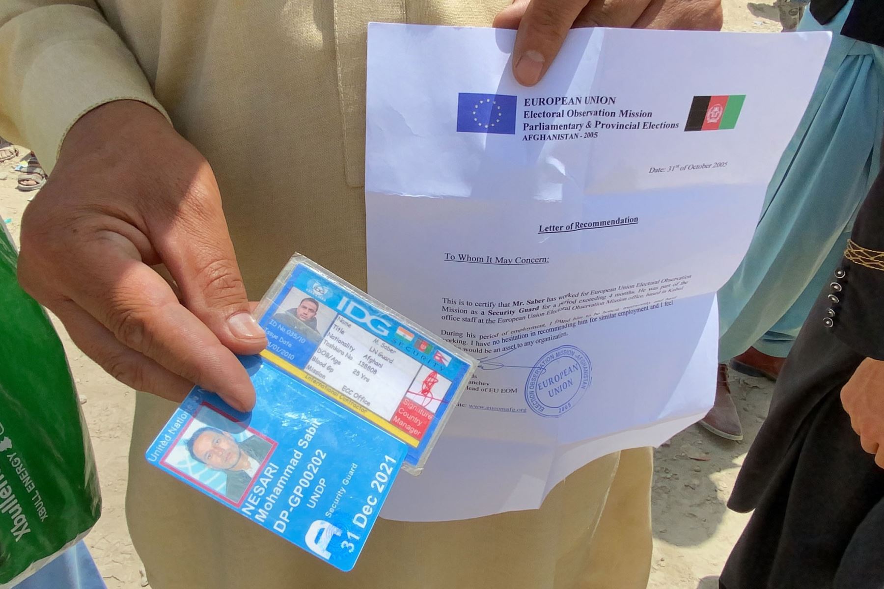 Un afgano que trabajaba para la Unión Europea en Afganistán muestra sus documentos mientras espera fuera del aeropuerto internacional Hamid Karzai para huir del país, después de que los talibanes tomaran el control de Kabul, Afganistán.
Foto: EFE