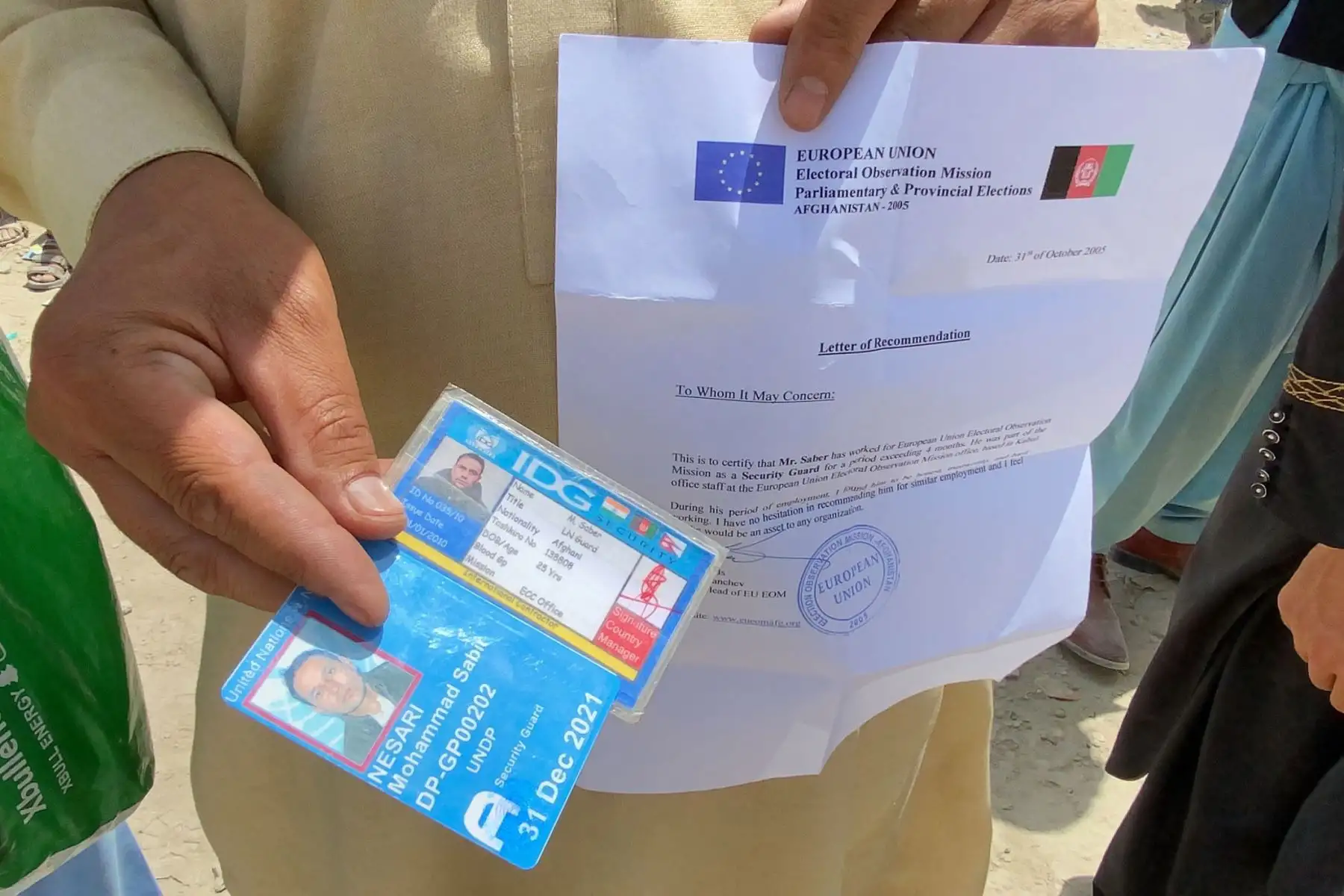 Un afgano que trabajaba para la Unión Europea en Afganistán muestra sus documentos mientras espera fuera del aeropuerto internacional Hamid Karzai para huir del país, después de que los talibanes tomaran el control de Kabul, Afganistán.
Foto: EFE