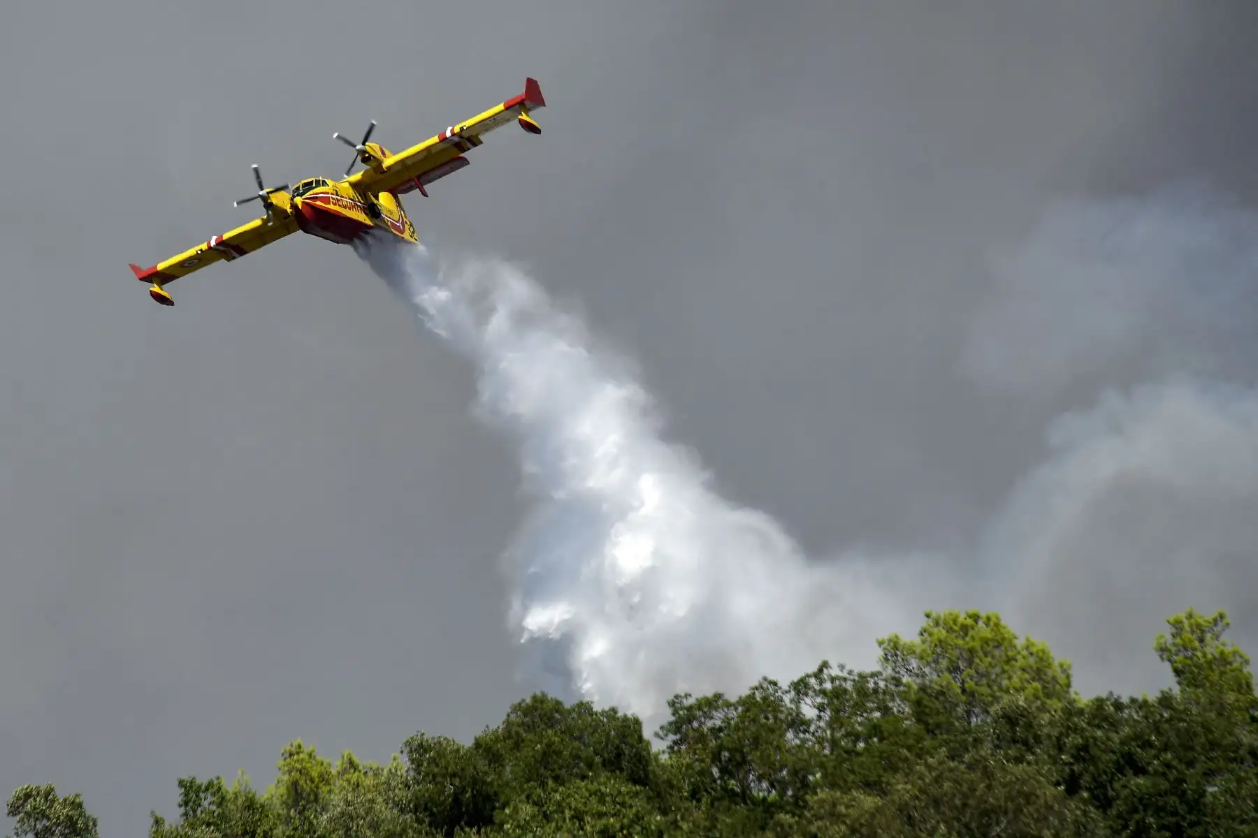 Un Canadair CL 415 deja caer agua para extinguir un incendio forestal en Gonfaron, en el departamento francés de Var, en el sur de Francia.
Foto: AFP