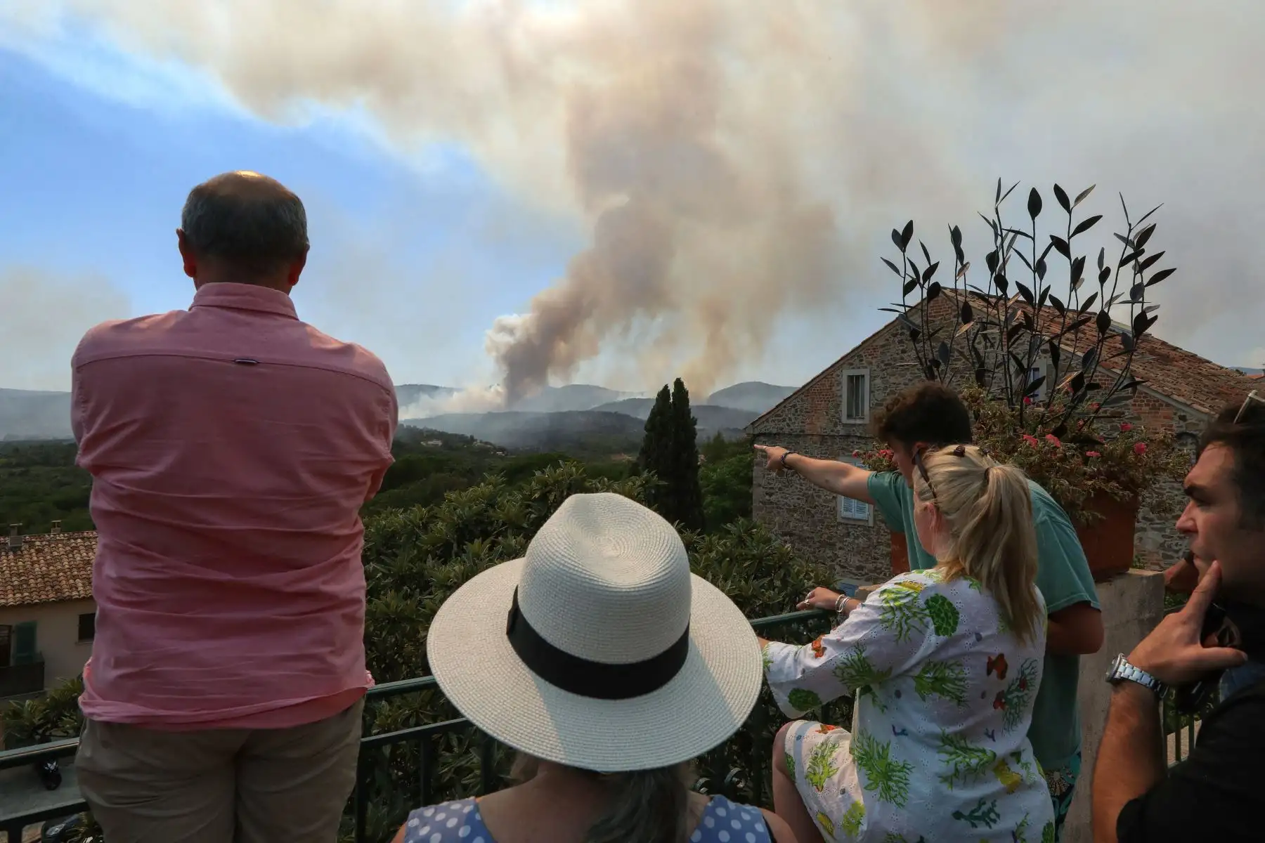 Los habitantes de la aldea de Grimaud, en el departamento de Var, observan cómo los incendios forestales se desatan en el sureste de Francia.
Foto: AFP