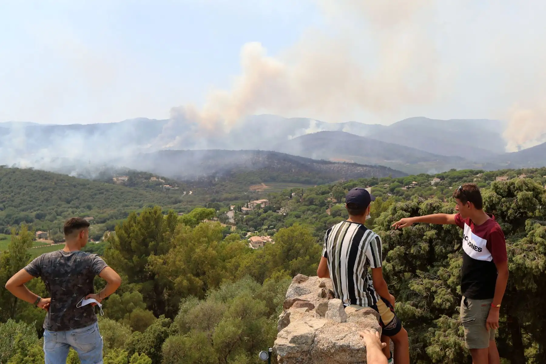 La gente obserba desde sus casas  de Chateau de Grimaud mientras ven los incendios forestales en Cogolin y Val de Gilly  en el sureste de Francia.
Foto: AFP