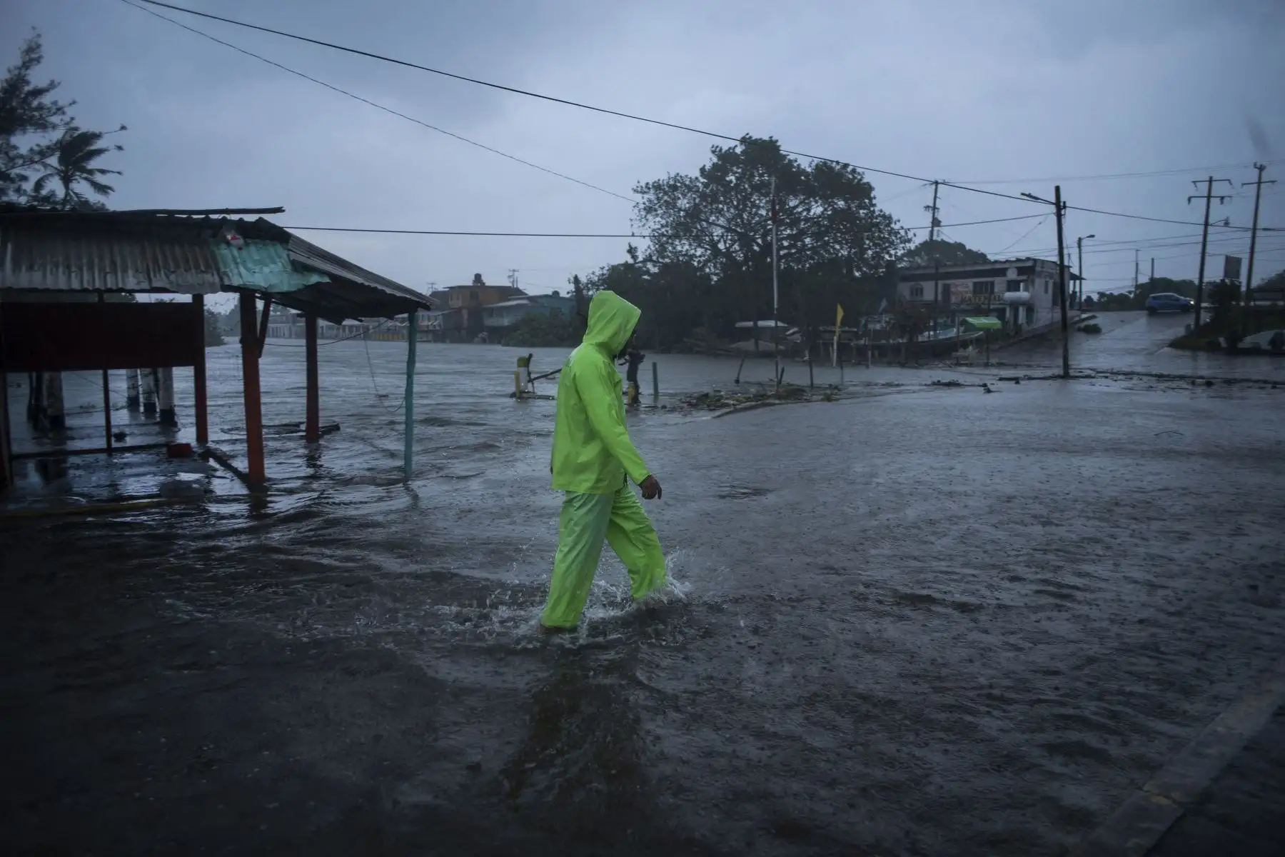 Un hombre camina en una calle inundada debido a las fuertes lluvias causadas por el huracán Grace en Tecolutla, Veracruz, México. Foto: AFP